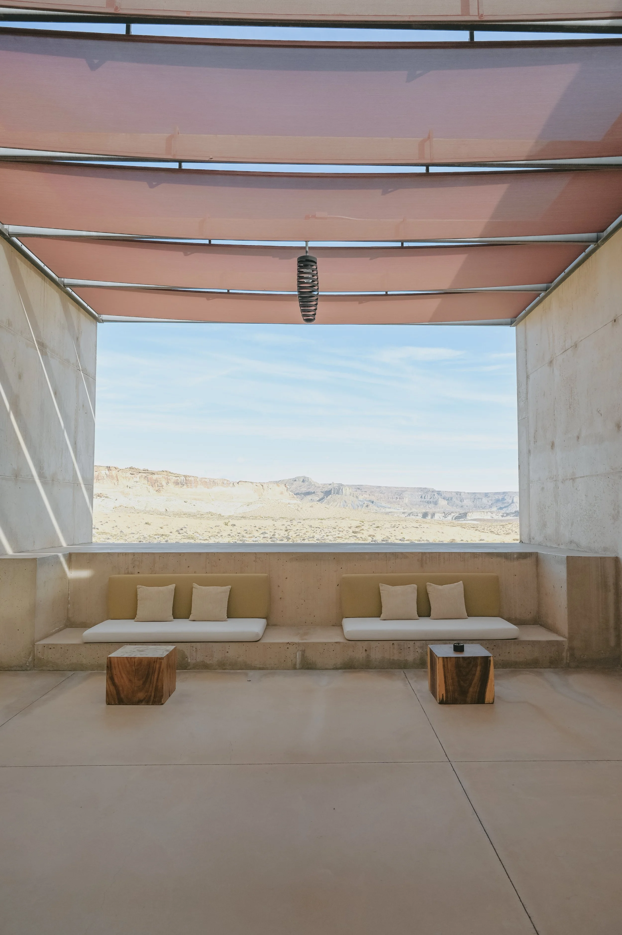 A concrete terrace with built-in seating framing a wide desert view.