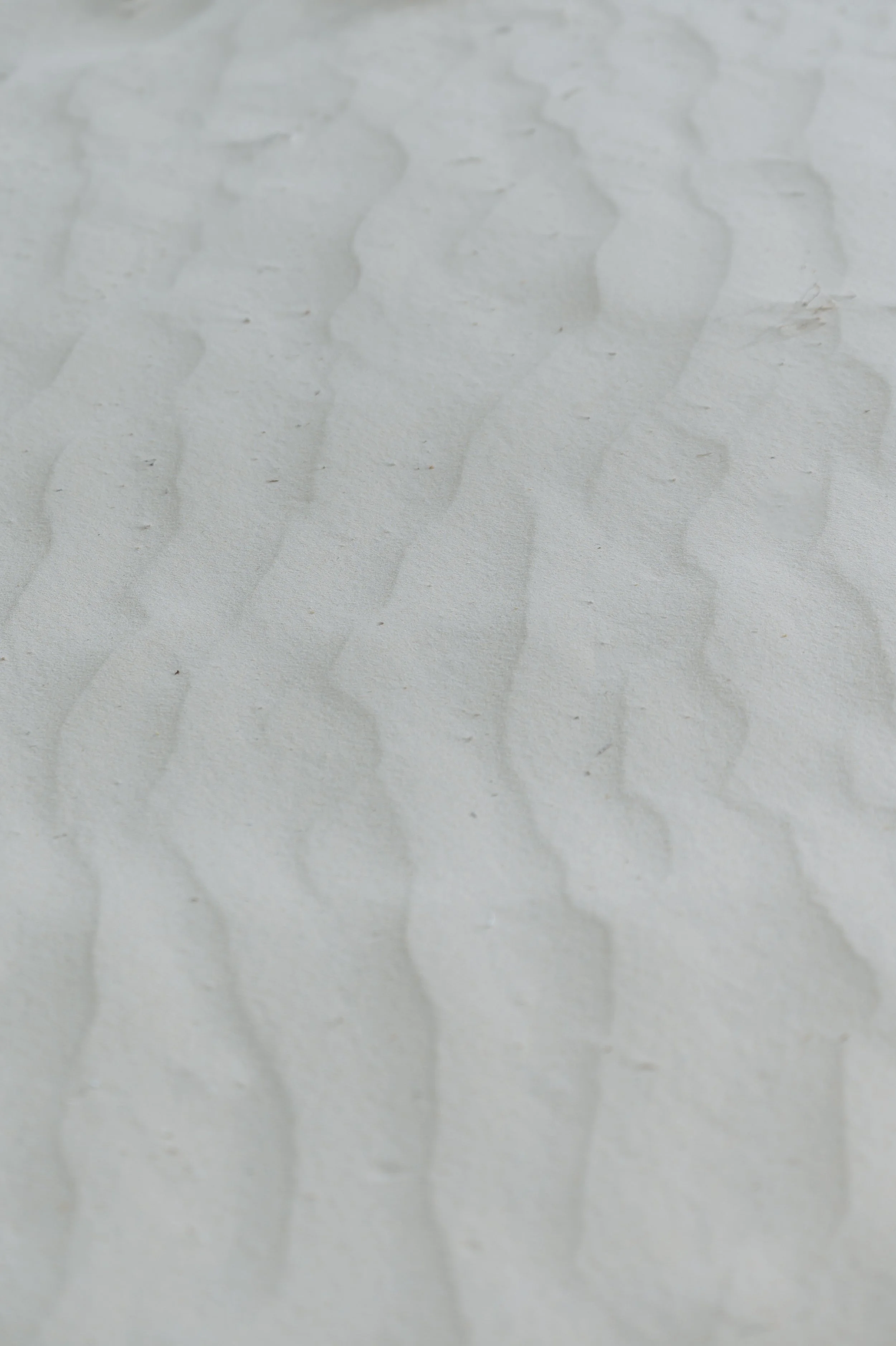 Soft ripples in pale desert sand.