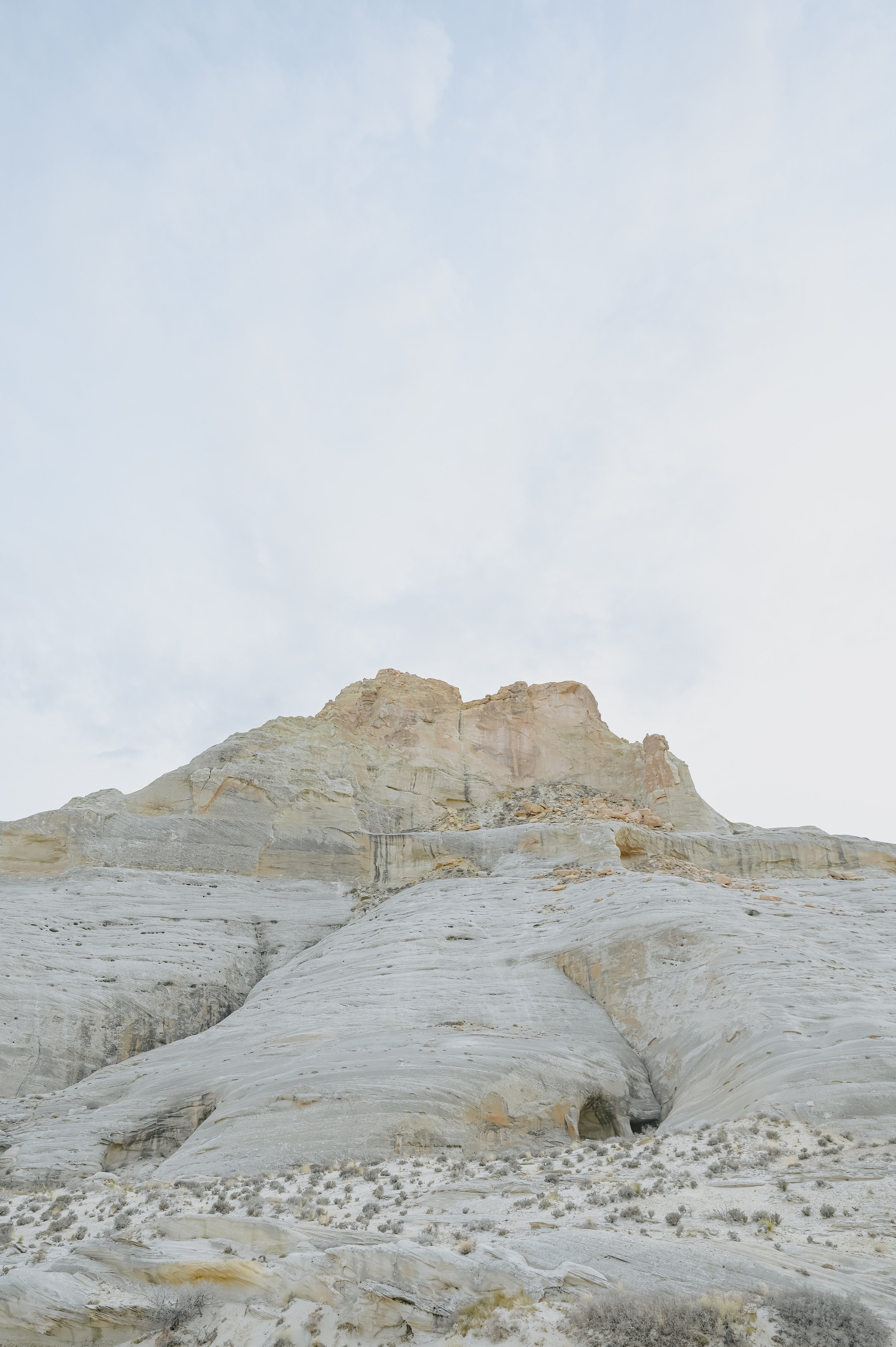 A pale rock butte rising under a soft cloudy sky.