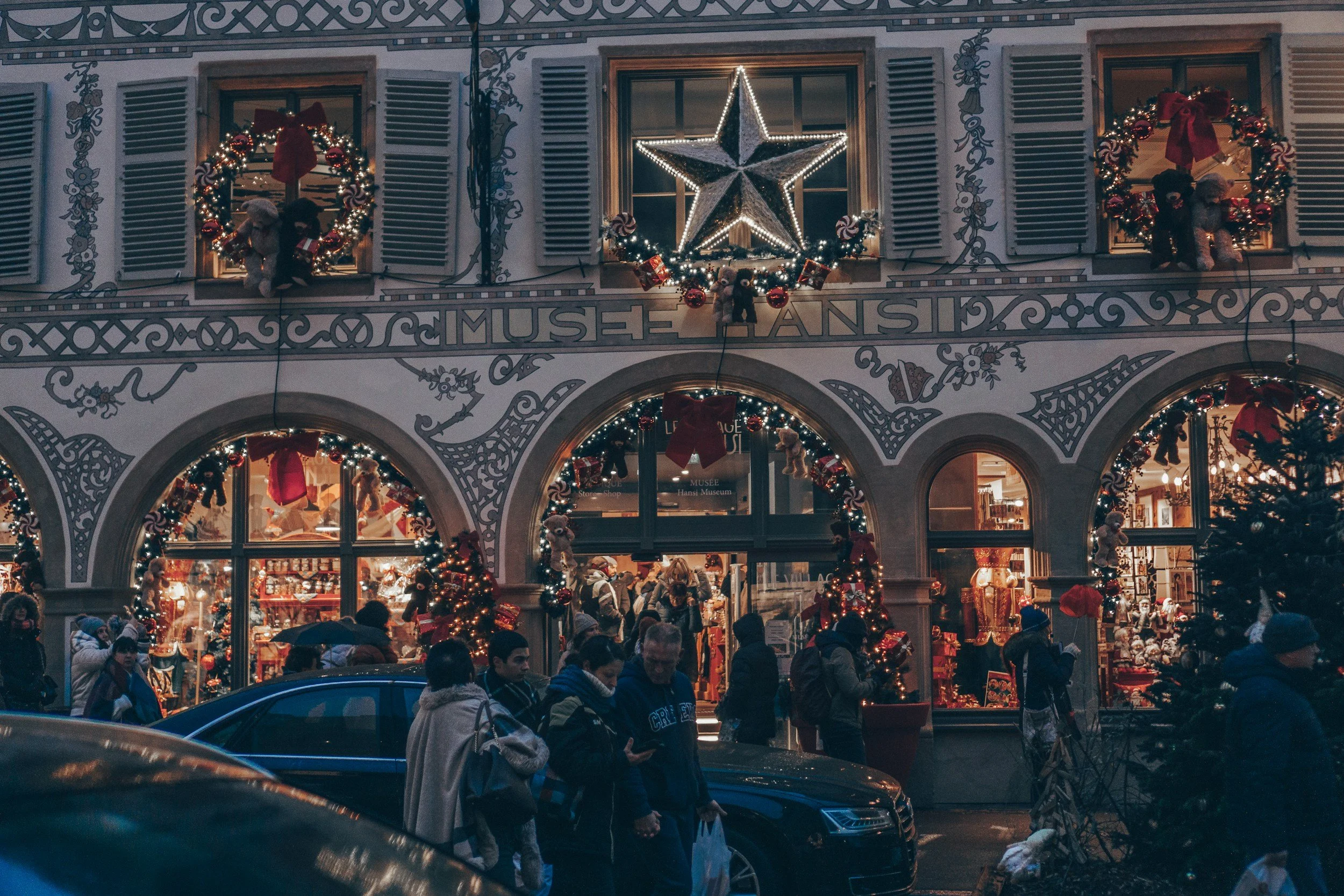 The Musee Hansi shopfront in Colmar decorated for Christmas with wreaths, garlands and a lit star