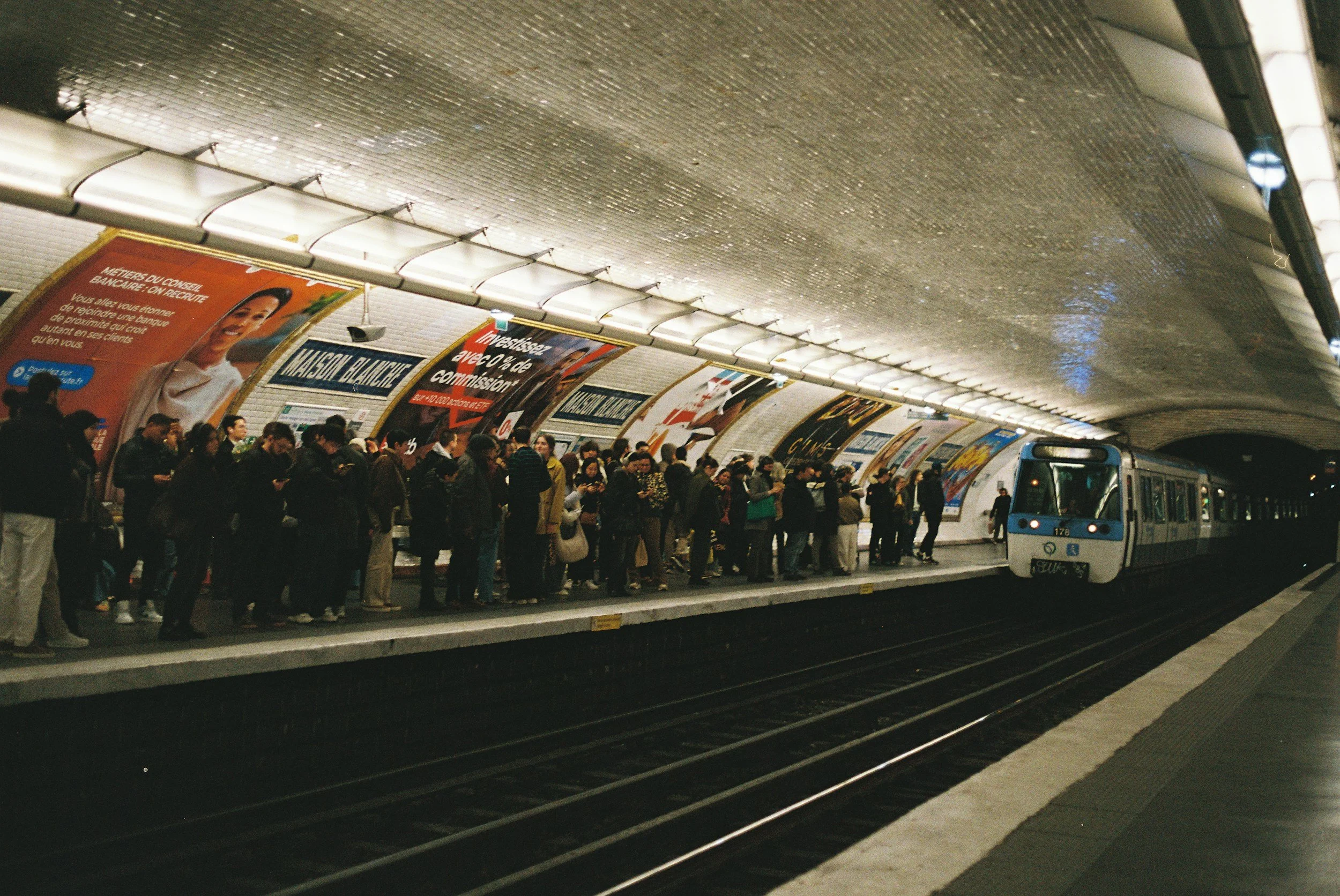 A crowded Paris metro platform as a train pulls into the station