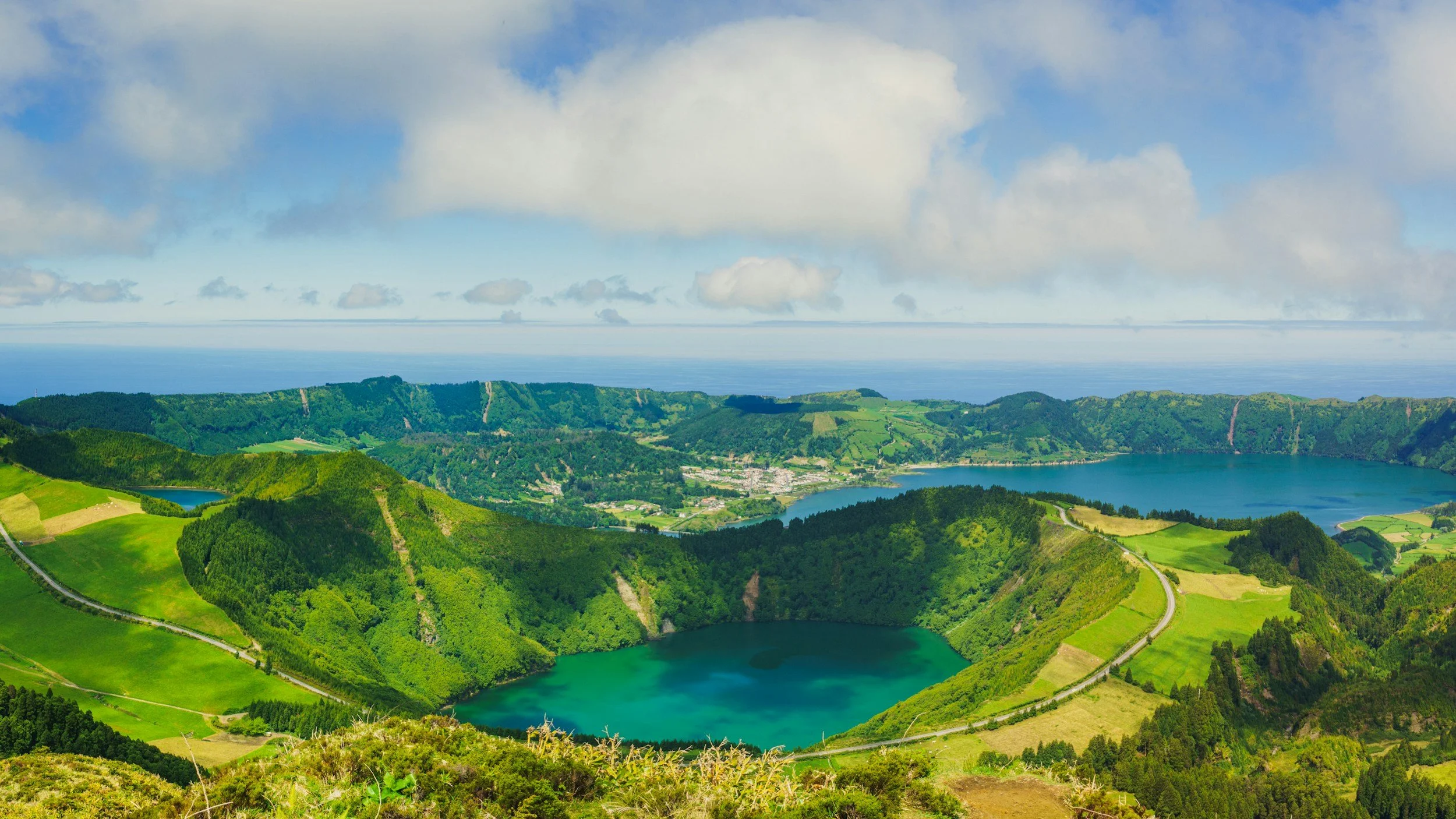Green volcanic crater walls around the blue lake at Sete Cidades on São Miguel in the Azores