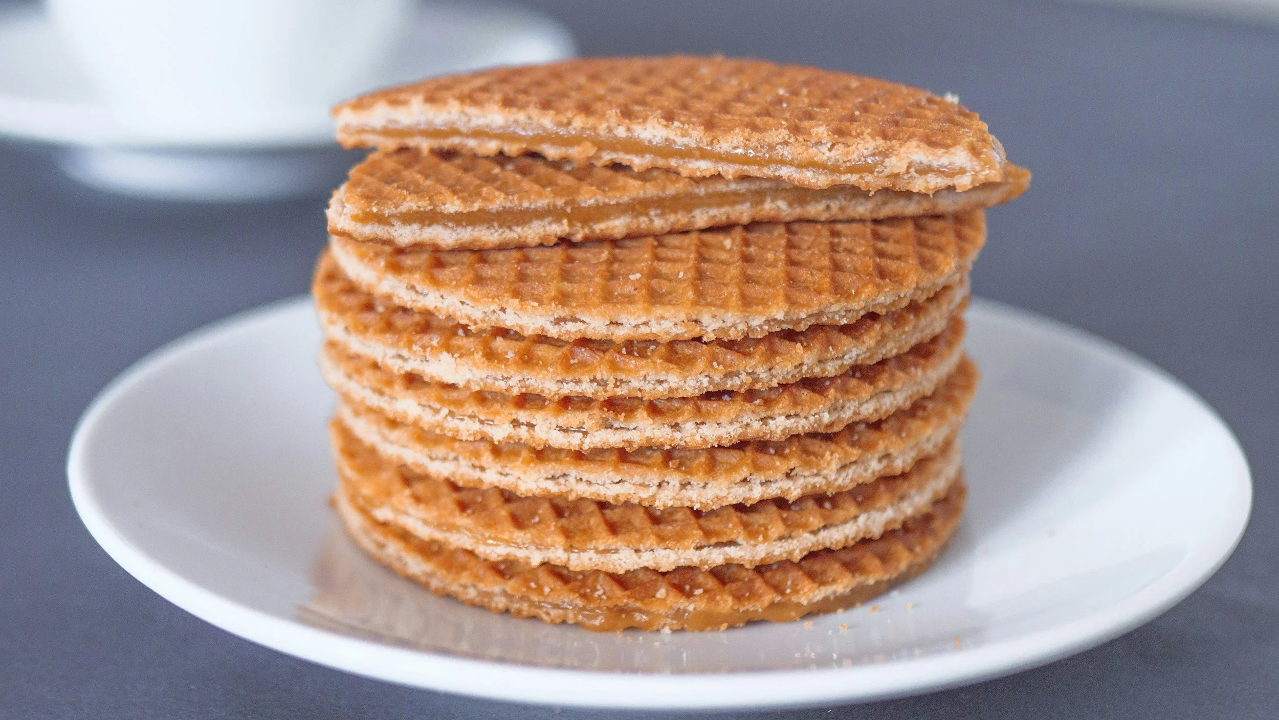 A tall stack of Dutch stroopwafels on a white plate