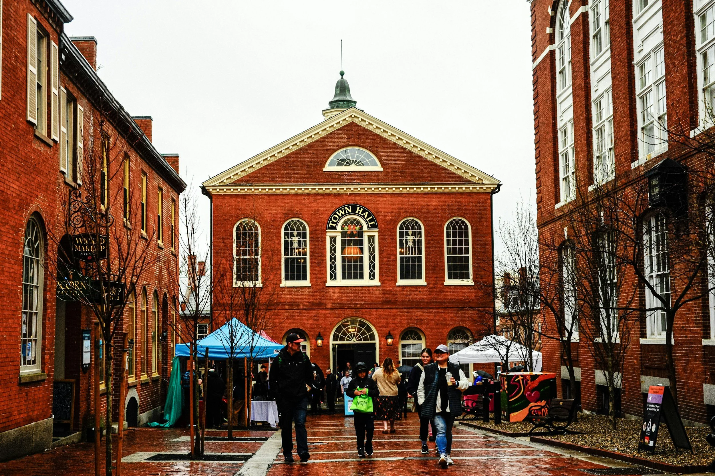 Visitors on a brick pedestrian street in front of the historic red-brick Old Town Hall in Salem, Massachusetts