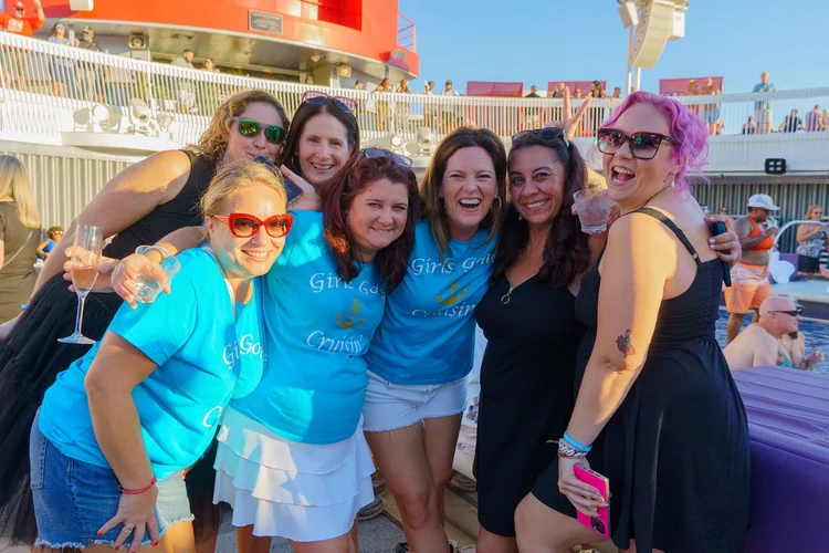 Women in matching Girls Gone Cruisin' shirts laughing in a selfie on deck