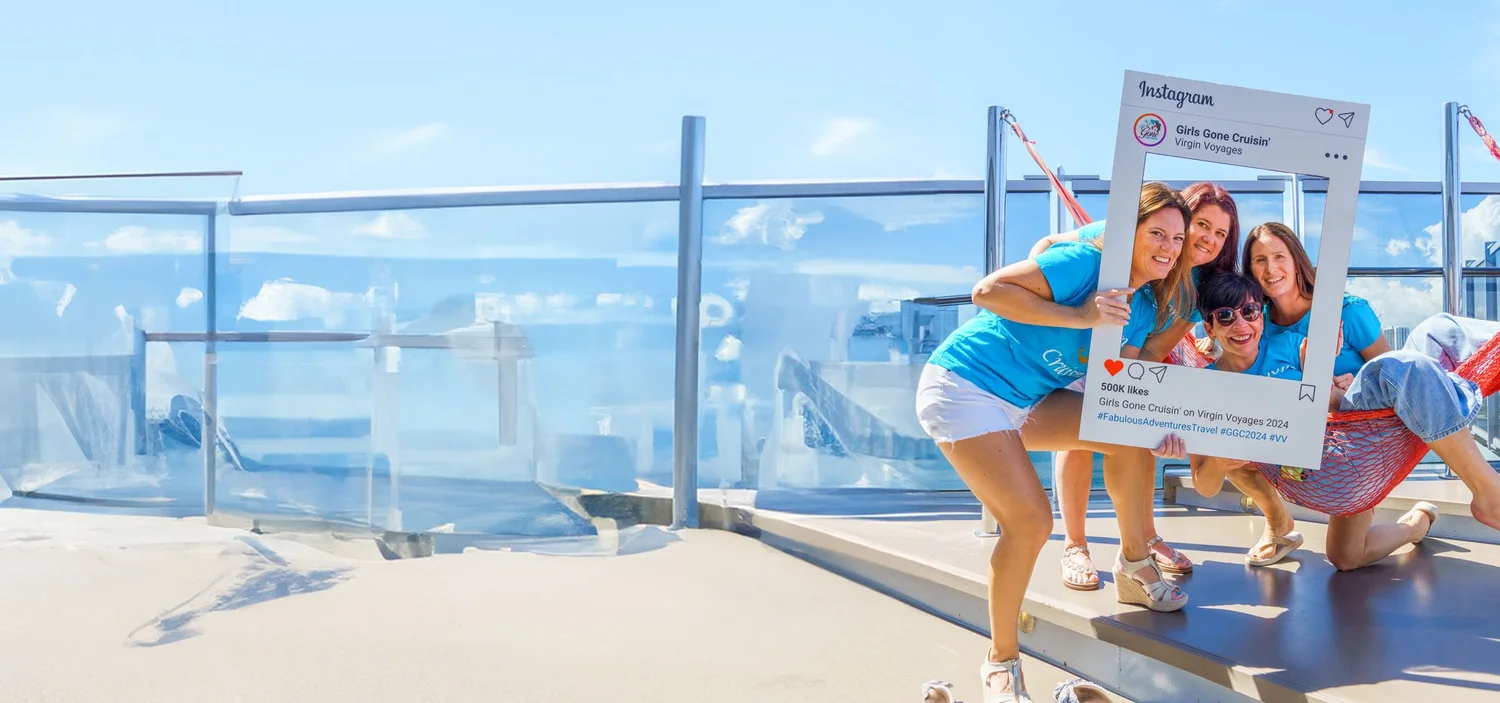 Four women in matching blue Girls Gone Cruisin' T-shirts posing in a giant Instagram frame on a ship's deck