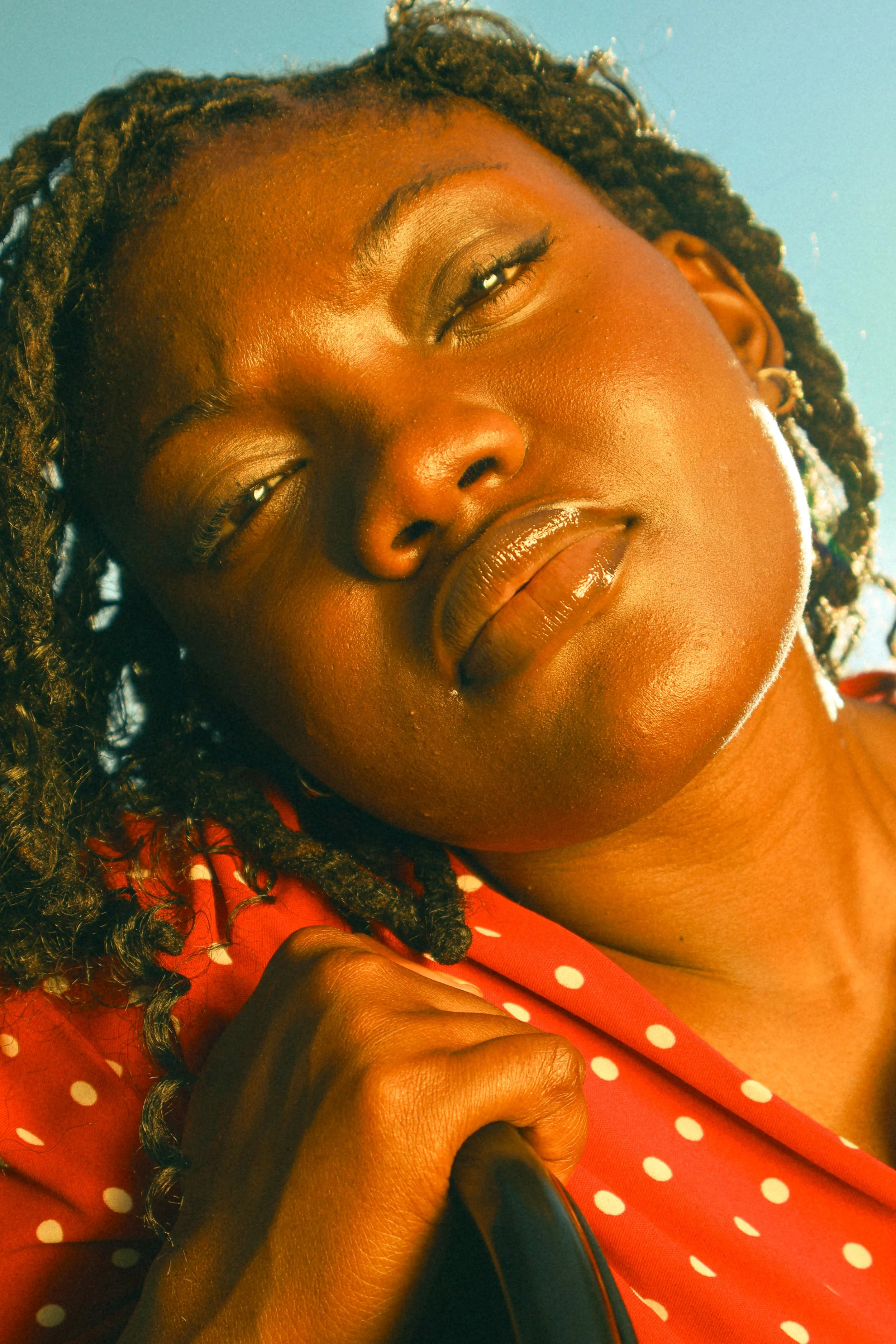An editorial portrait photograph of Jane Simataa sitting on a chair with the sky behind her taken by Kim Kambinda in Windhoek, Namibia.