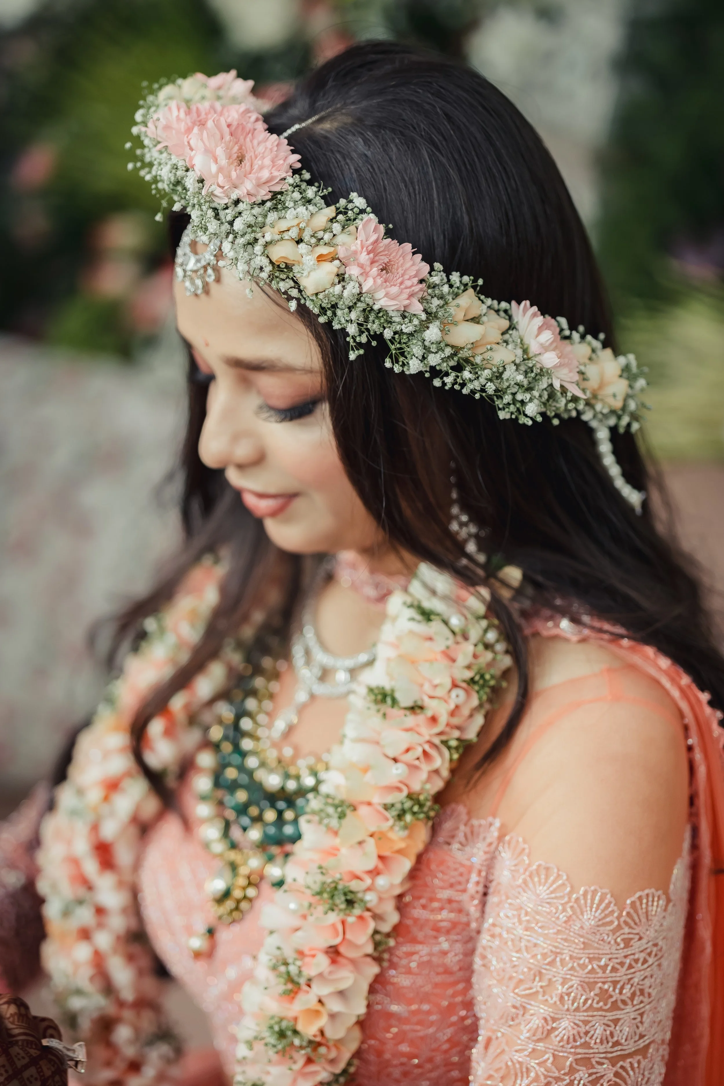 A woman wearing a floral crown, traditional wedding dress, and jewelry.