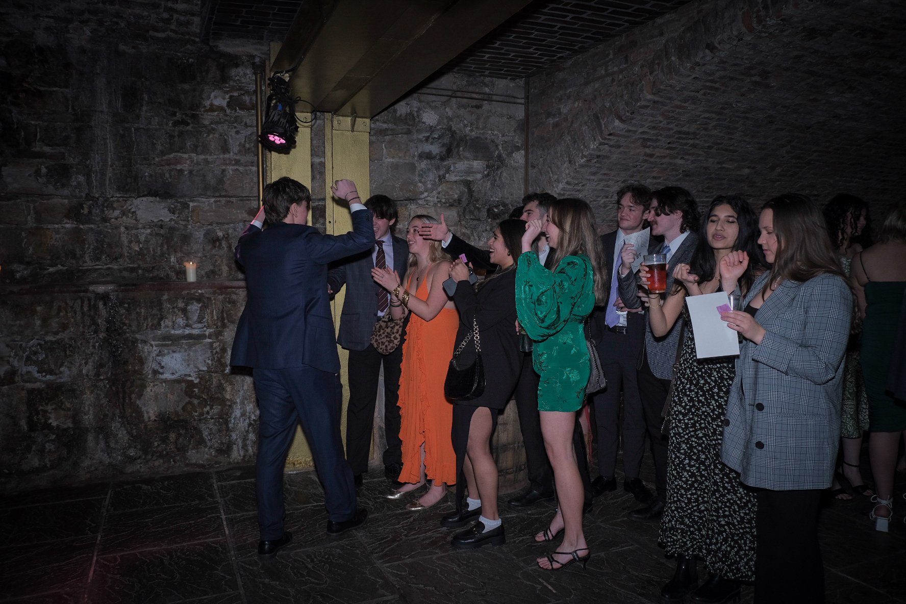 Group of people at a party dancing and smiling together indoors.