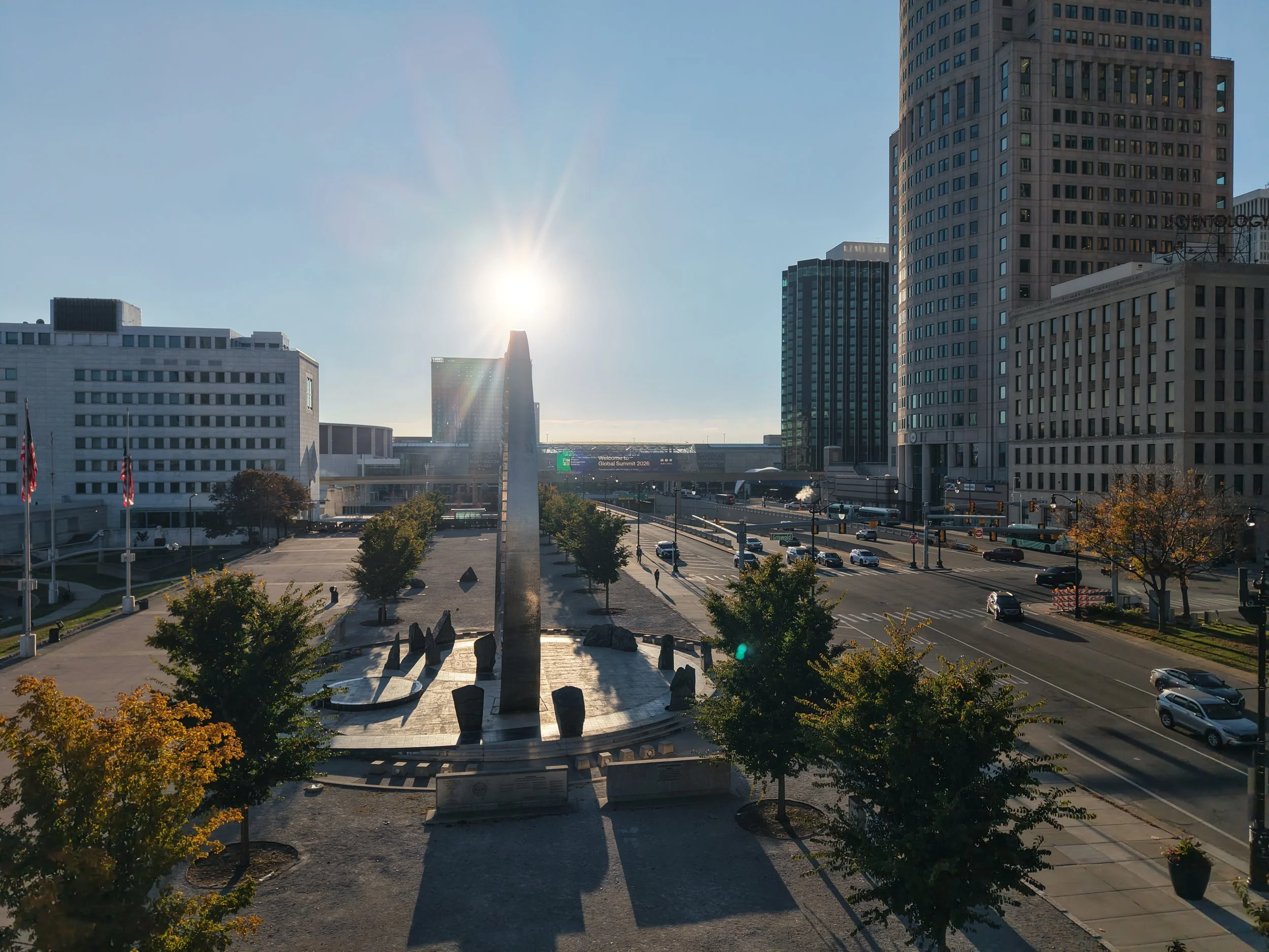 Downtown Detroit skyline featuring office buildings, city streets, and traffic.