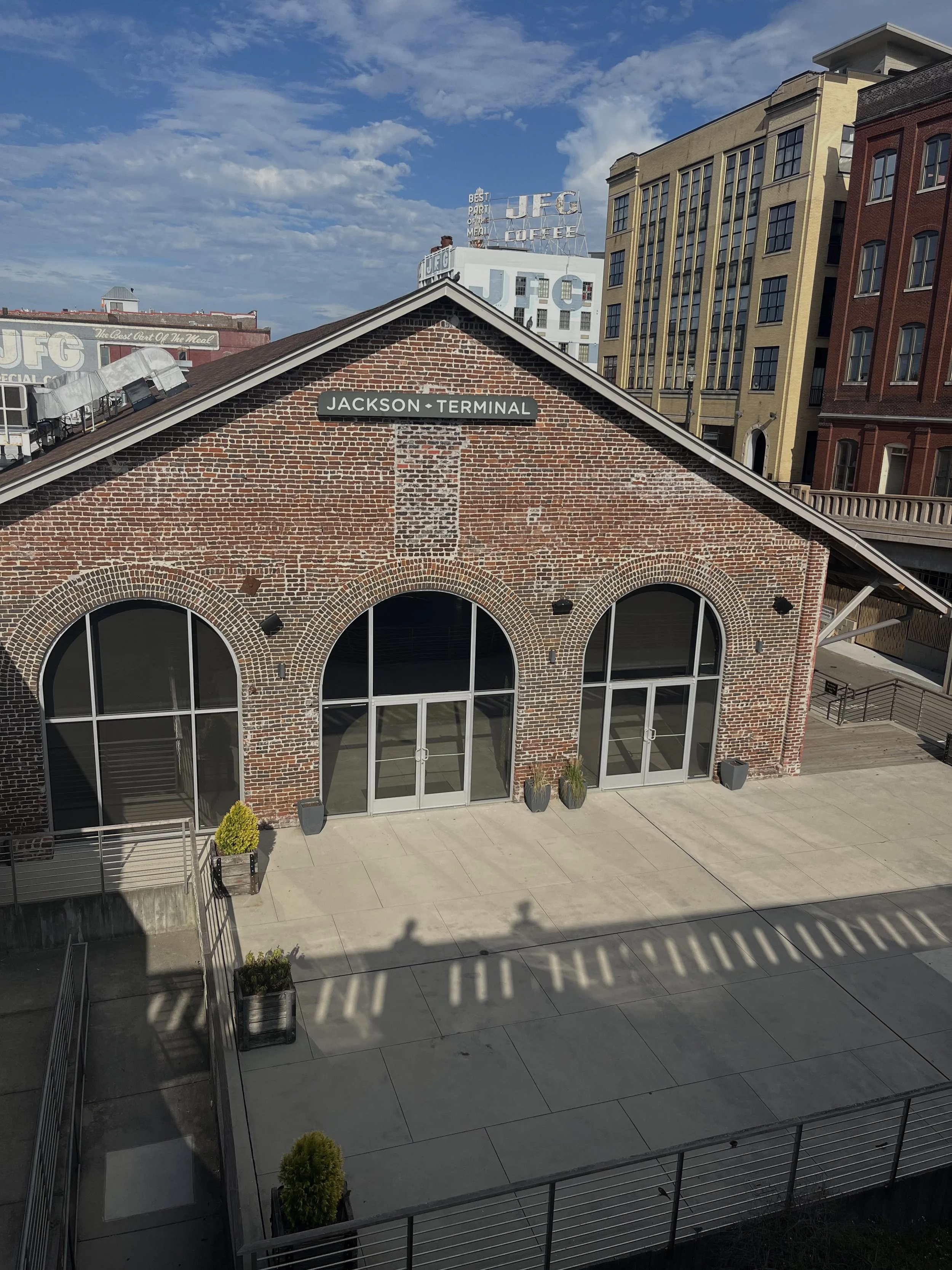 Historic brick Jackson Terminal building with arched windows and rooftop UFG coffee sign under a blue sky