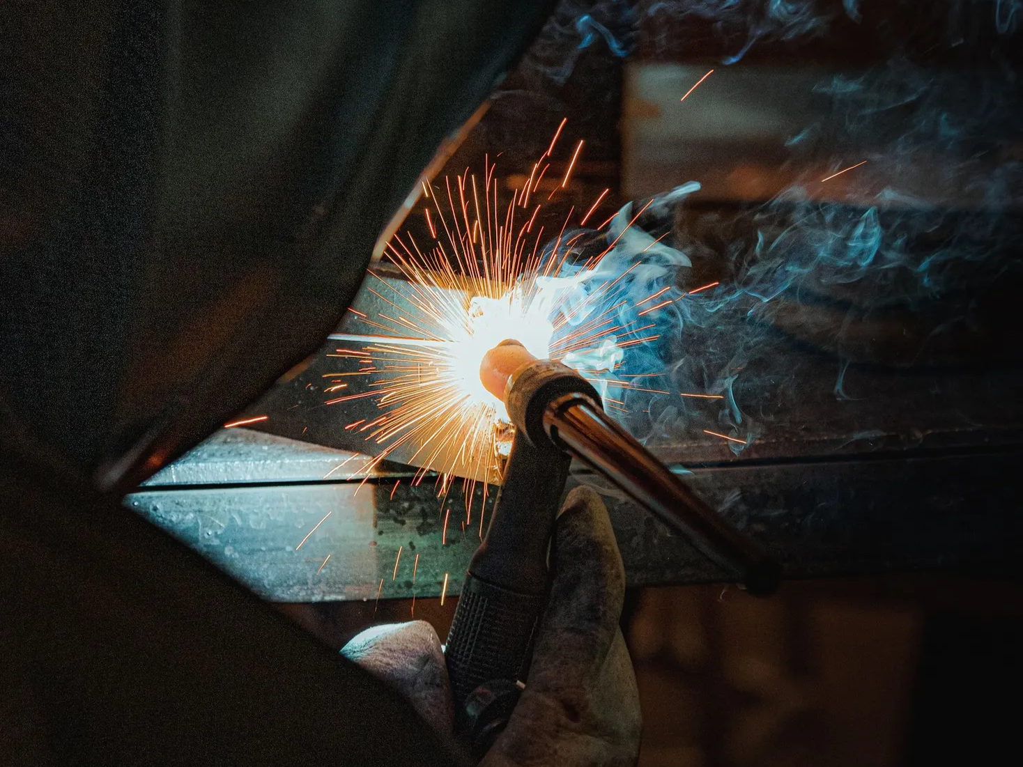 Close-up of welding in progress at PlazCutz, showing a bright welding arc and sparks during metal fabrication work in our engineering workshop.