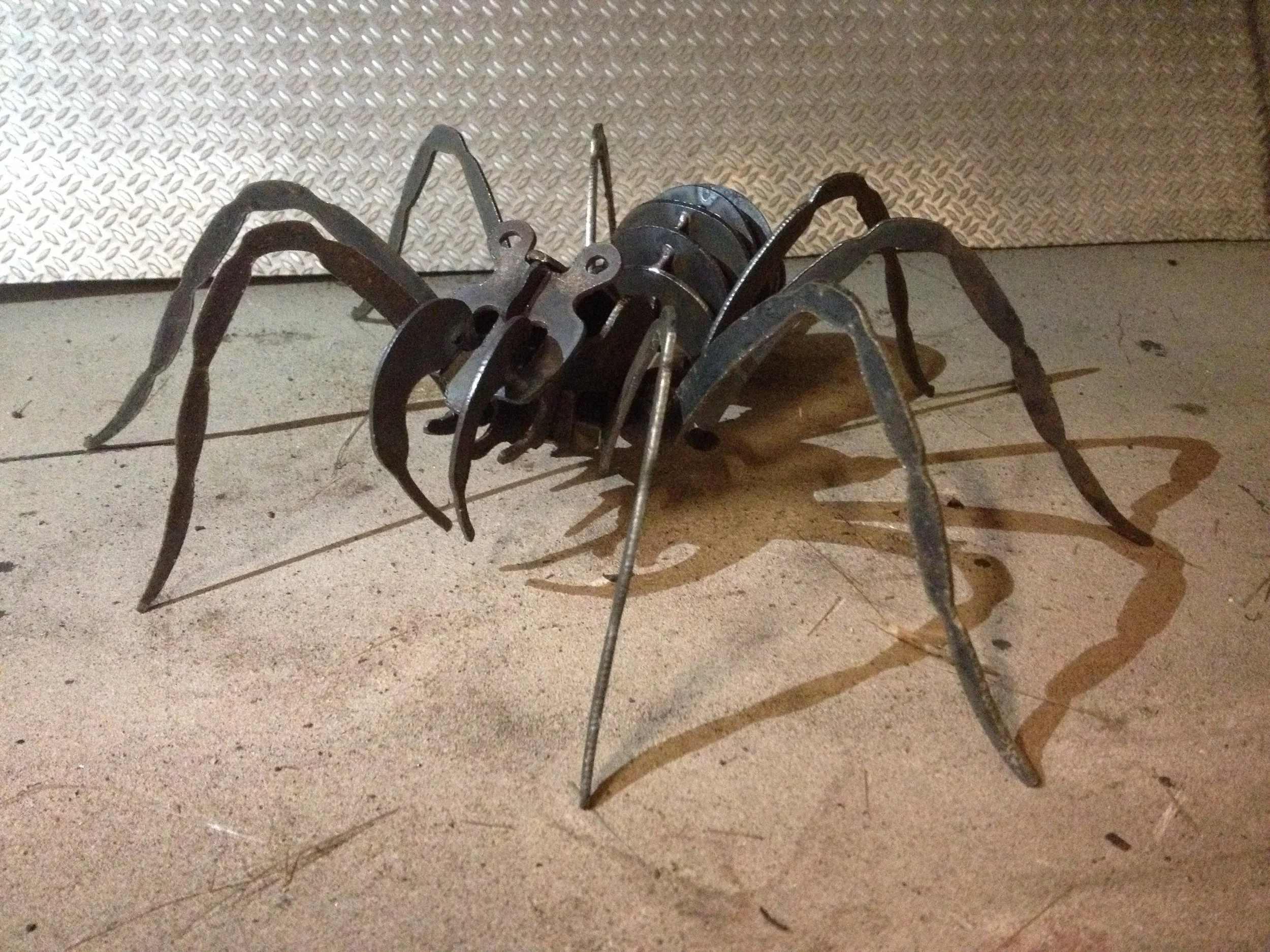 Finished 3D metal spider sculpture made from CNC plasma-cut steel, featuring eight long curved legs and an interlocking segmented body assembled using the downloadable Spider DXF design.