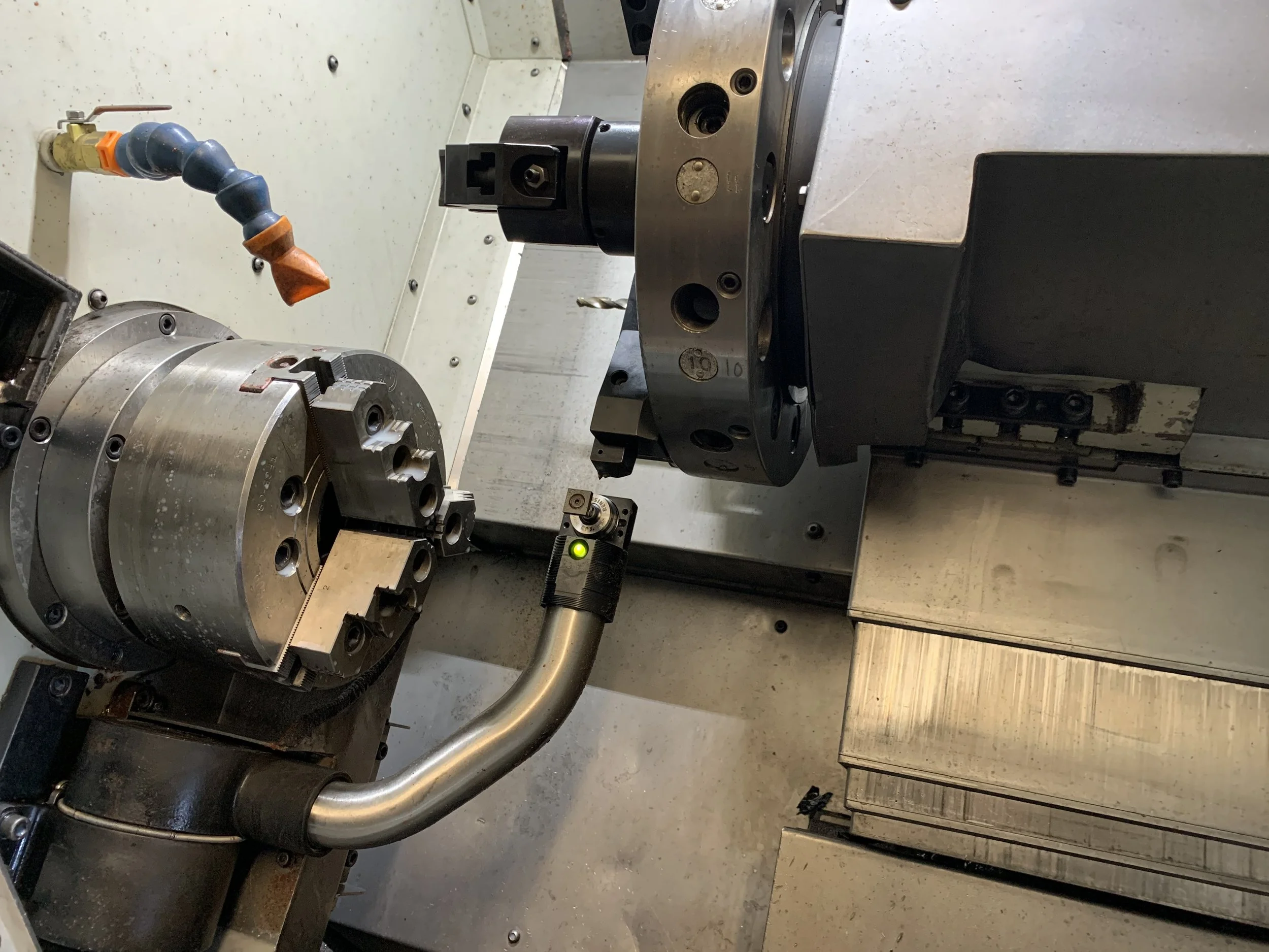 Inside the PlazCutz Hardinge Talent CNC turning lathe, showing the machine's chuck and tooling used to manufacture precision-turned engineering components.