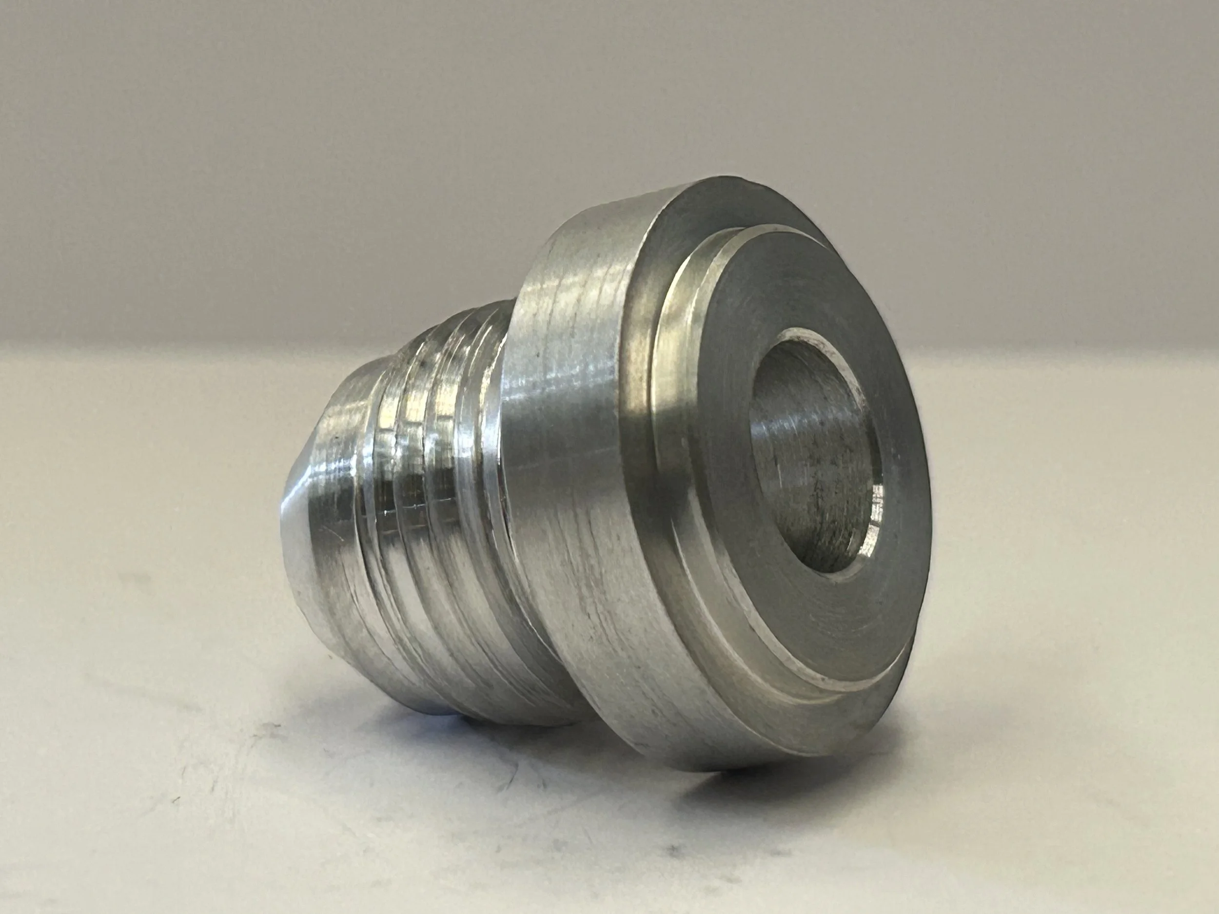 Rear three-quarter view of an AN-10 JIC male weld-on hose fitting in 6082 T6 aluminium, showing the machined weld flange, central bore and thread.
