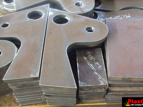 CNC plasma-cut mild steel profiling plates stacked after cutting, showing precision-cut shapes and mounting holes.