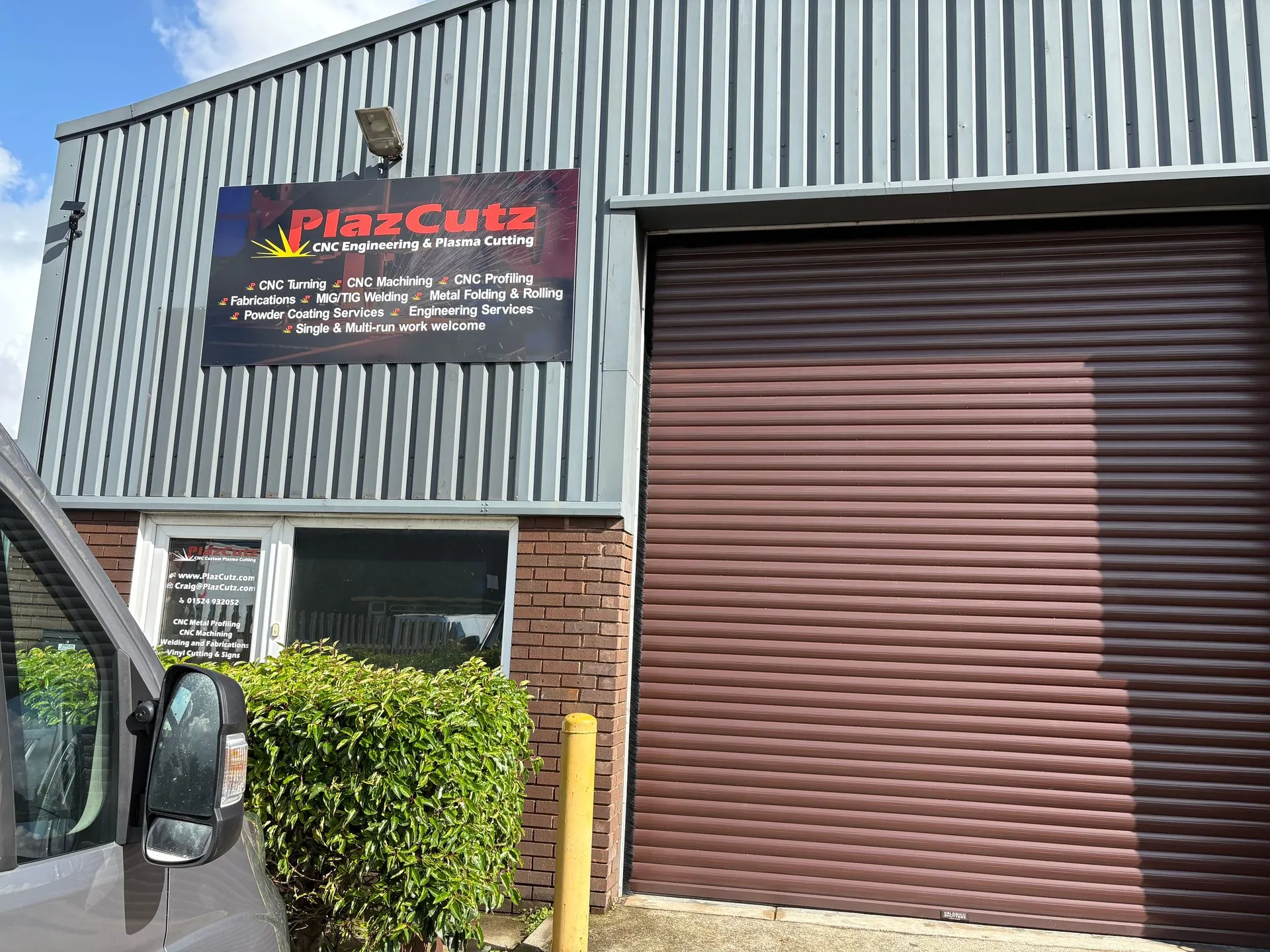 PlazCutz Ltd engineering workshop in Morecambe, Lancashire, showing the company signage, entrance and roller shutter door. The premises house our CNC plasma cutting, machining, turning, welding, fabrication and powder coating services.