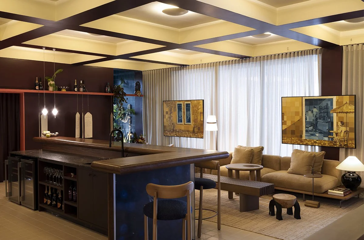 Sala de estar moderna com sofá bege, várias mesas de centro de madeira, janelas grandes com cortinas brancas, televisão, iluminação suave, e decoração aconchegante.
