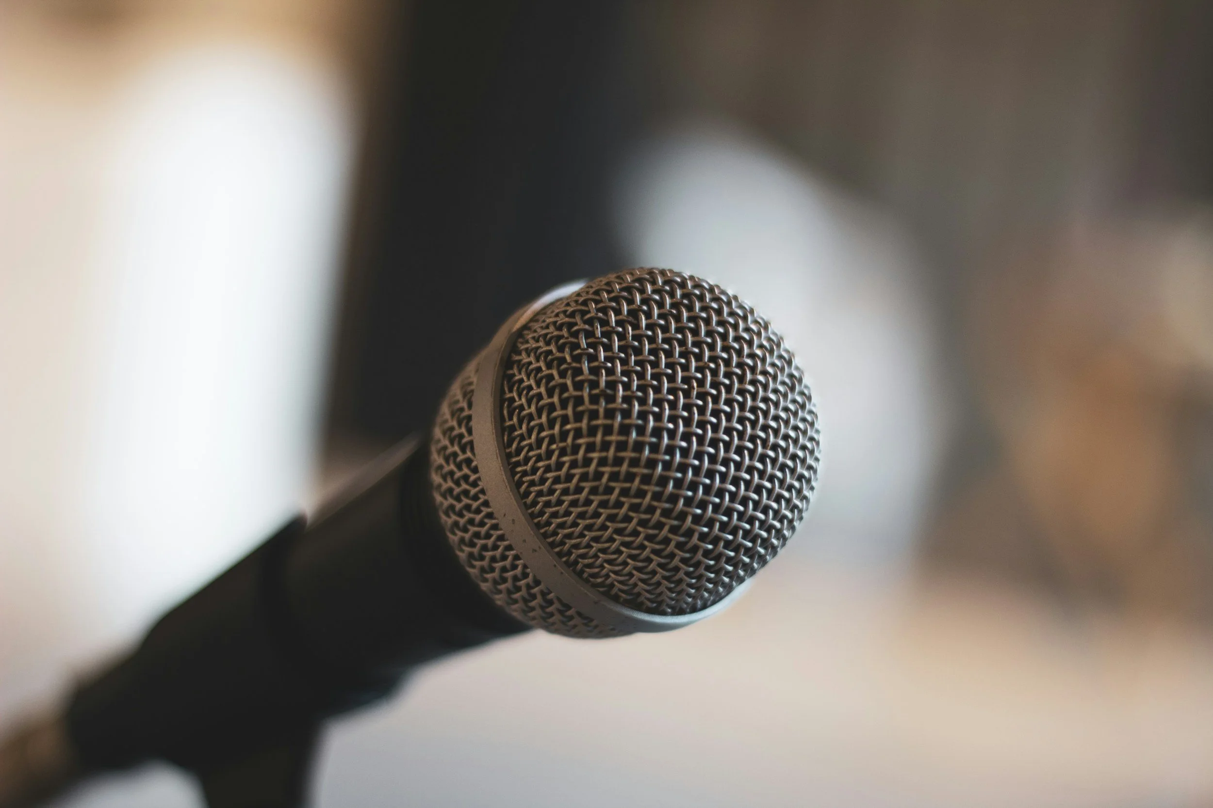 Close-up of a vintage metal mesh microphone with warm lighting and a blurred background