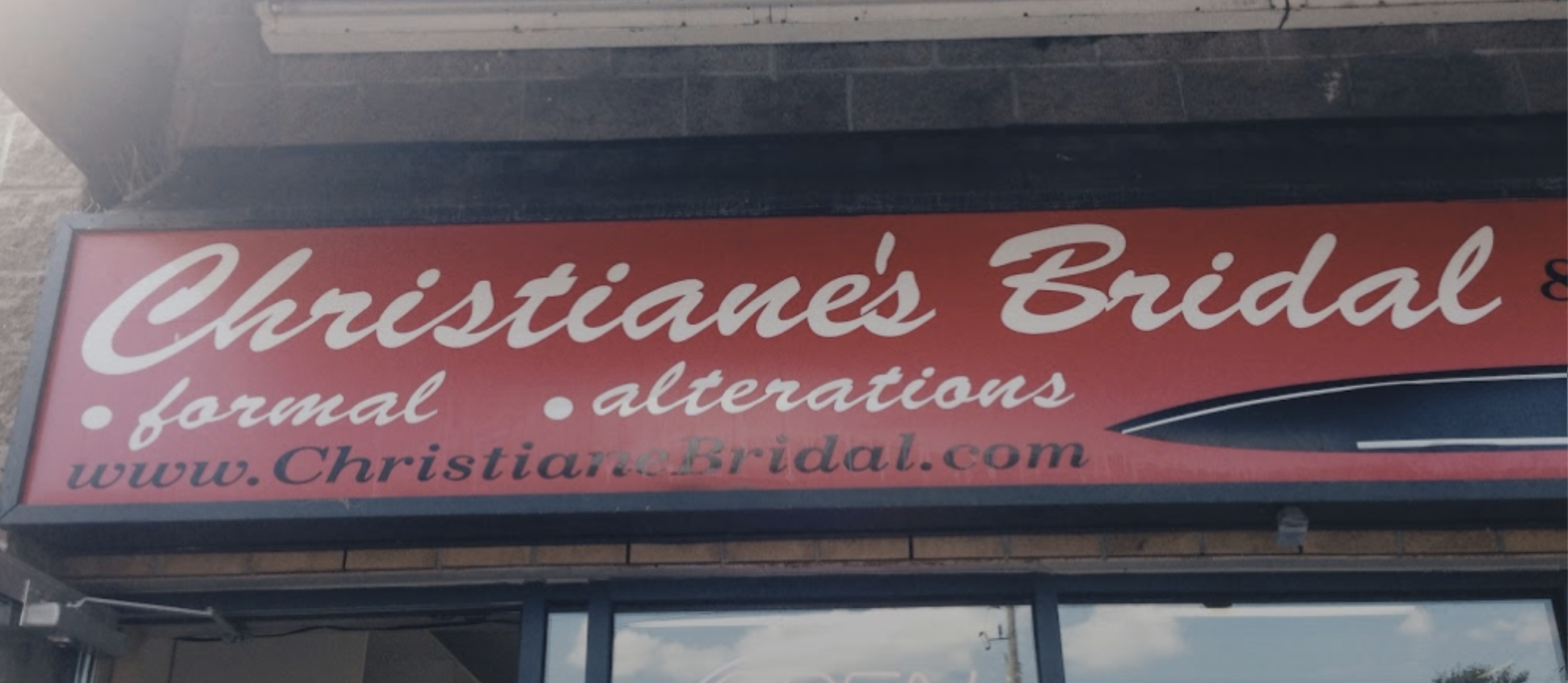 bridal shop sign advertising formal wear and alterations, with an arrow pointing right.