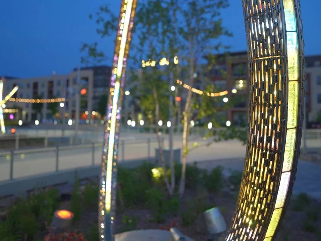 An illuminated sculpture made of stainless steel, glass, and light