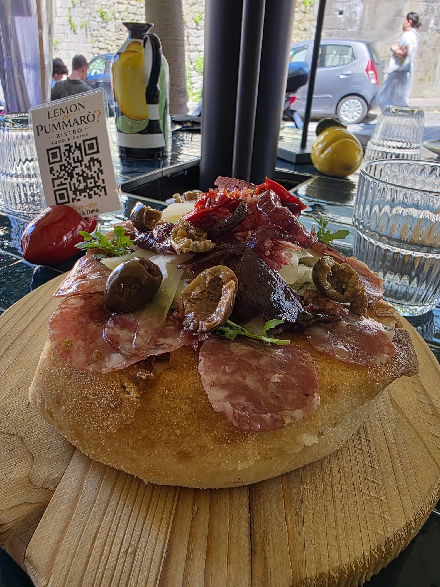 Tagliere rustico con salumi, formaggi, verdure sott’olio e pane, servito al bistrot con bottiglia di liquore al limone