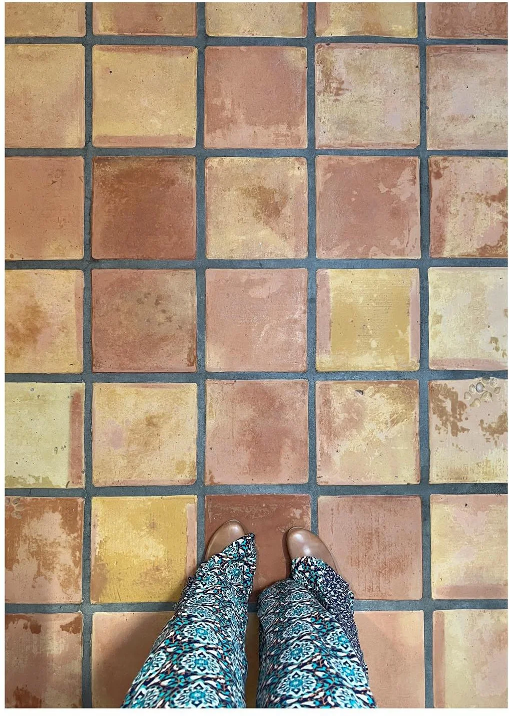 Original terracotta floor tiles with dark grout before restoration