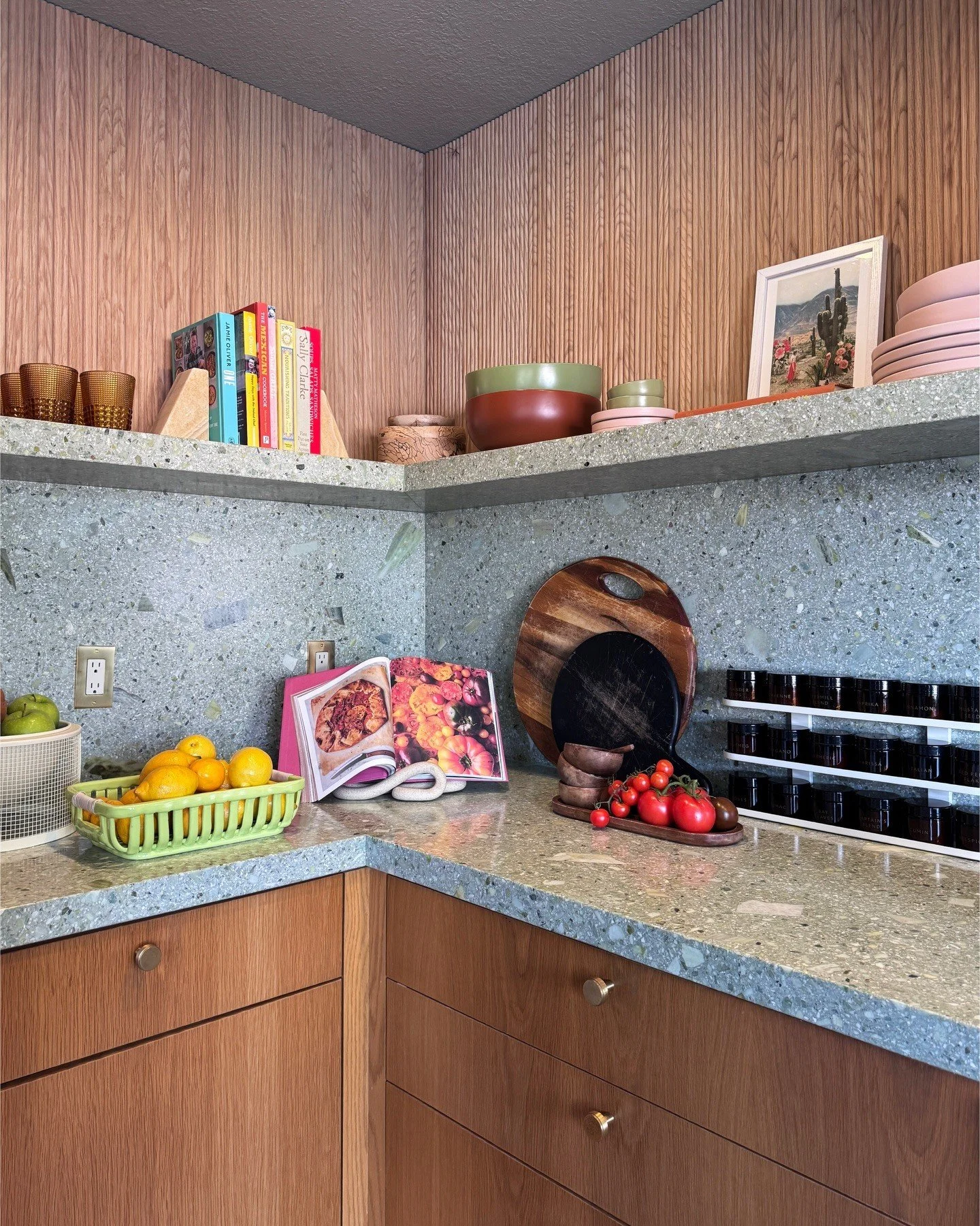 Wood kitchen shelves with bowls above a gray terrazzo counter
