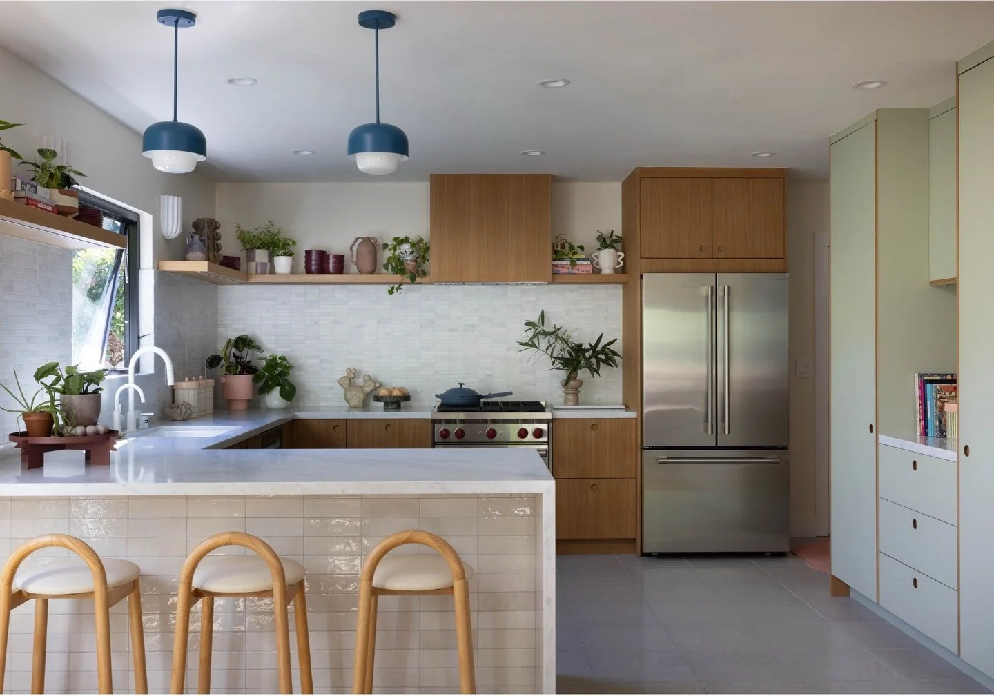 Kitchen with pale green pantry and blue pendant lights