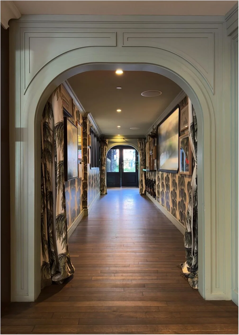 Arched pale doorway framing a patterned hotel corridor