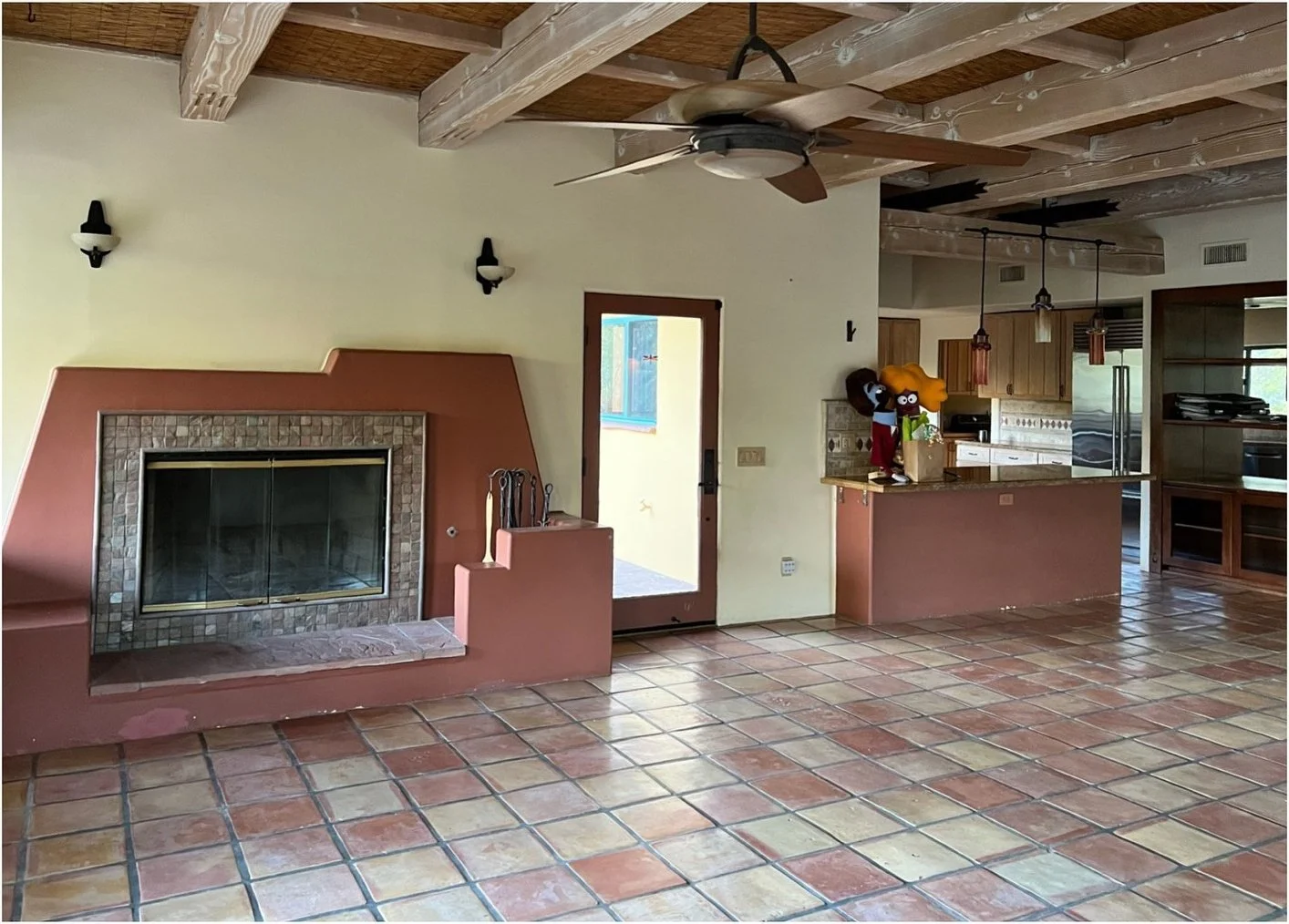 Original open living area with wood beams and terracotta flooring