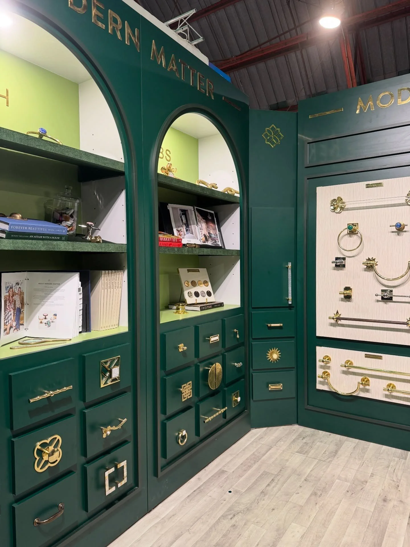 Green hardware booth with arched display niches and drawers
