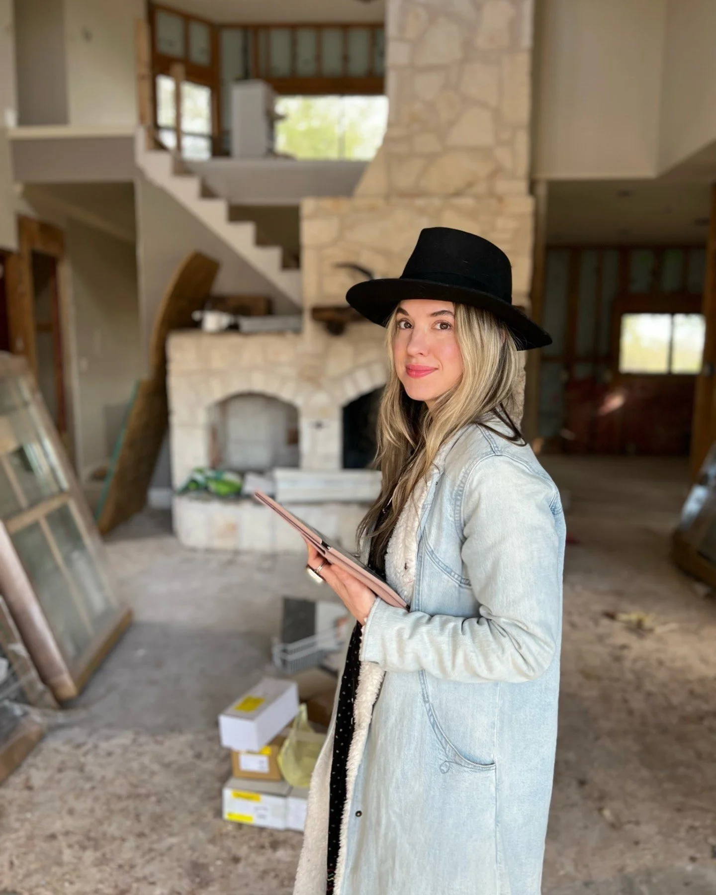 Amy holding a tablet at an interior renovation site
