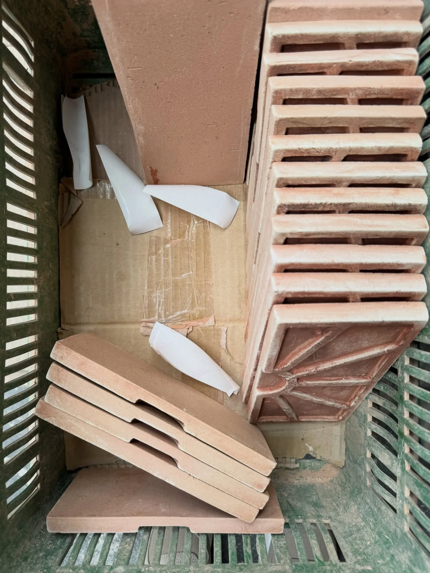 Stacks of pale clay trim and terracotta tile pieces