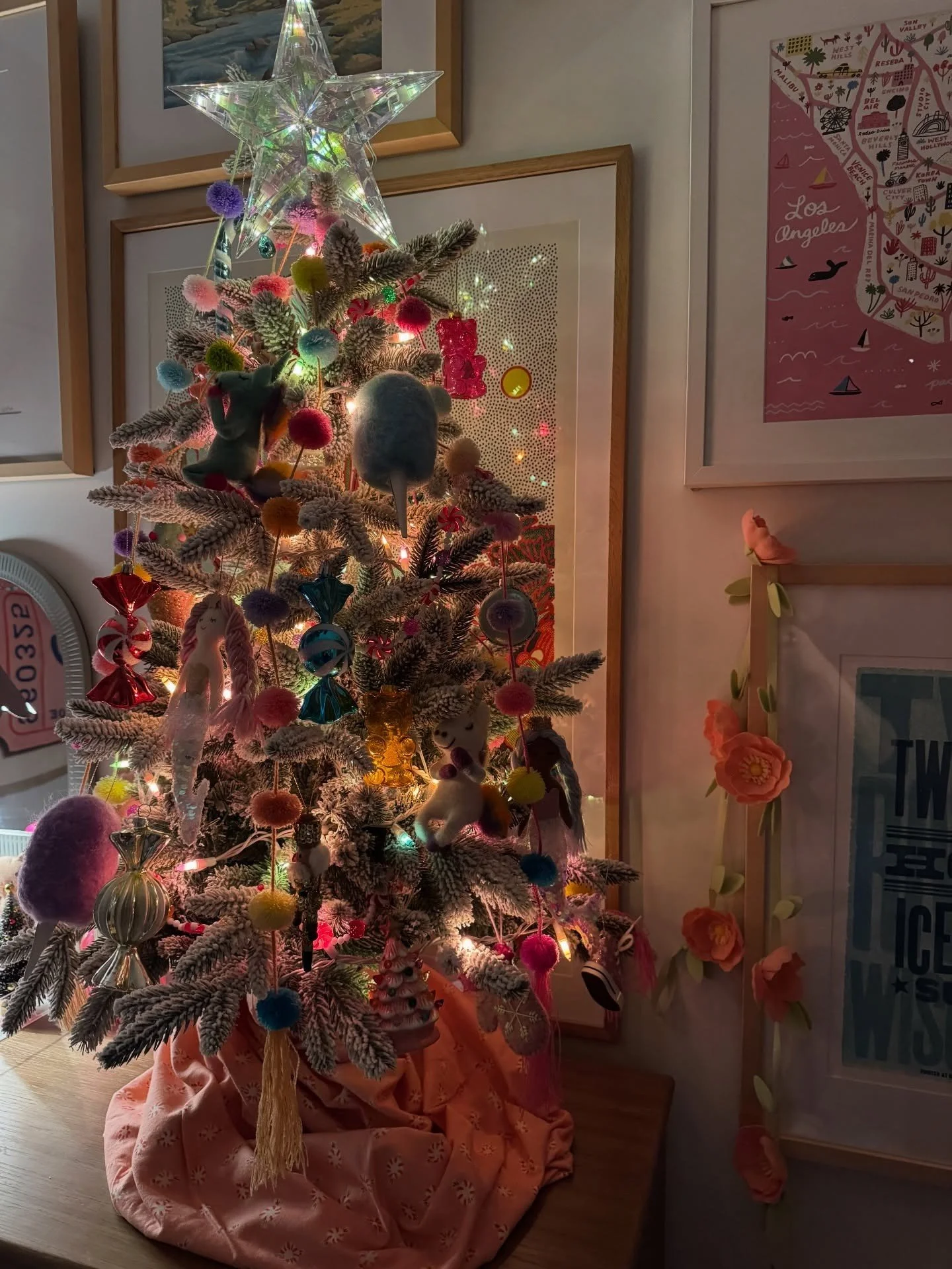 Slender Christmas tree with eclectic ornaments and framed art