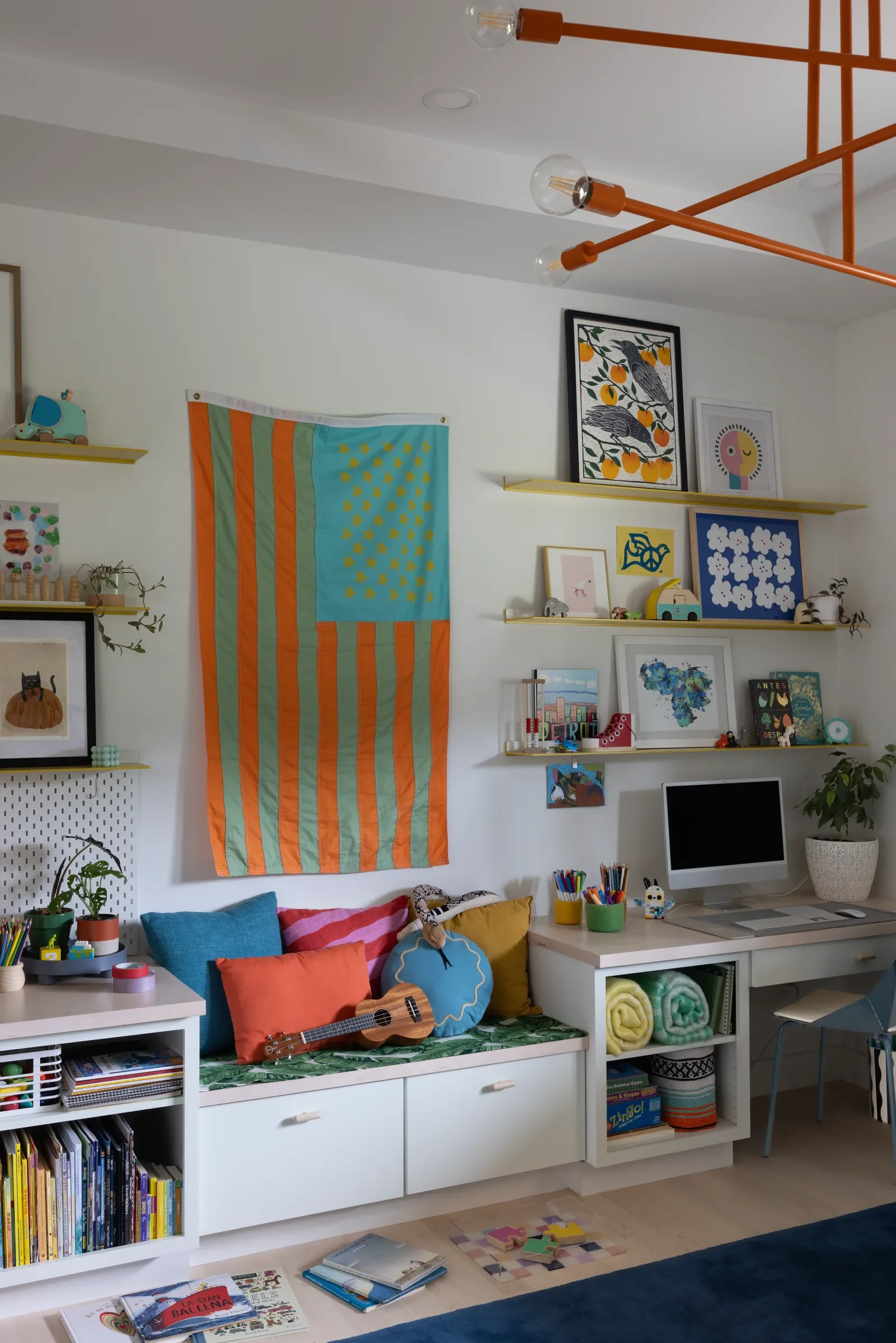 Colorful playroom with a window seat, desk, and shelves of toys.