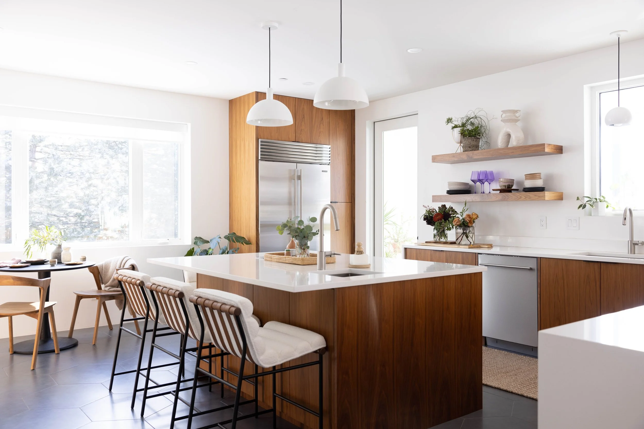 Bright kitchen with walnut cabinetry, a white island, and bar stools.