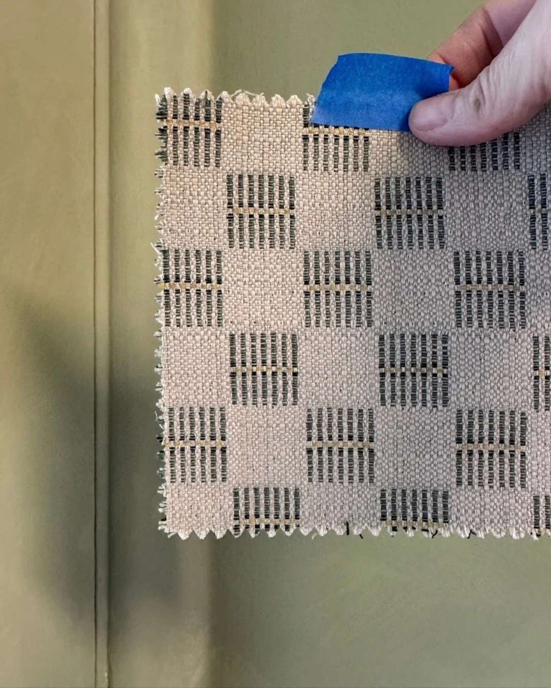 A textured checkerboard fabric swatch in natural and gray tones