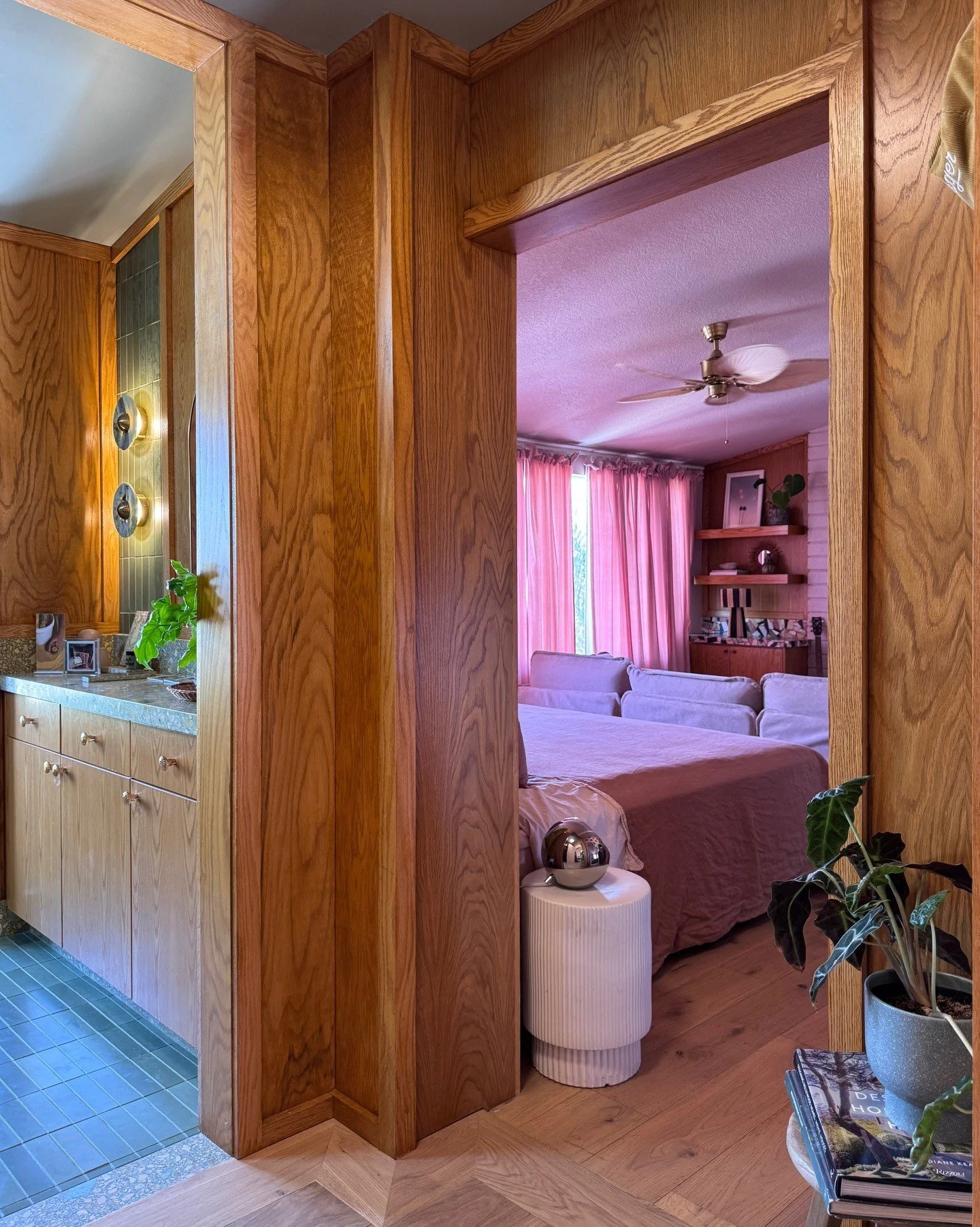 Bathroom doorway opening onto a pink bedroom