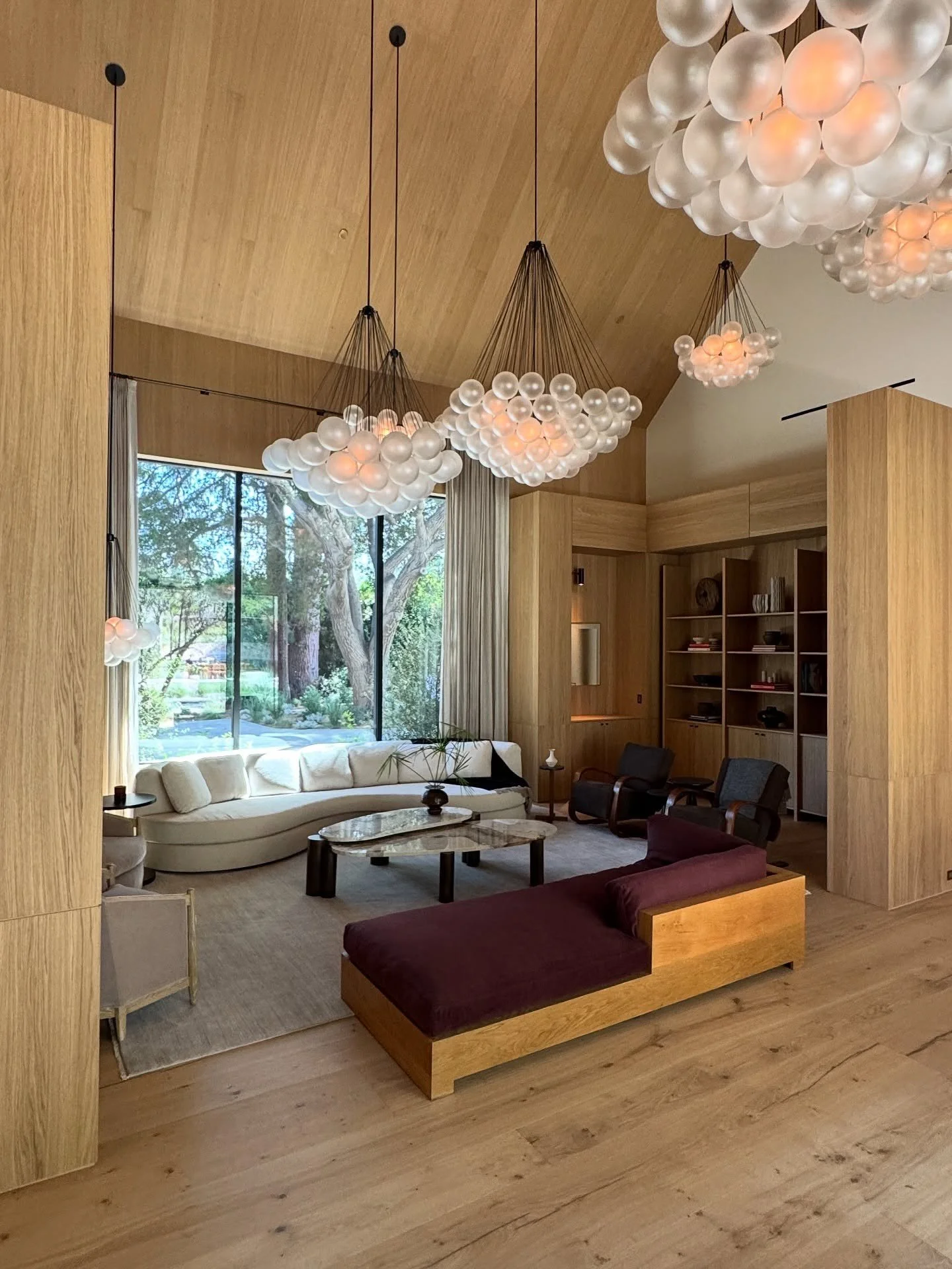 Timber-clad living space beneath sculptural glass chandeliers