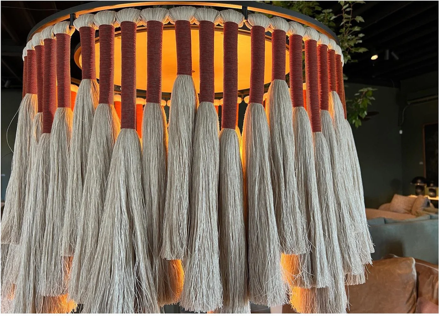 Detail of a circular chandelier with long hanging strands and warm light