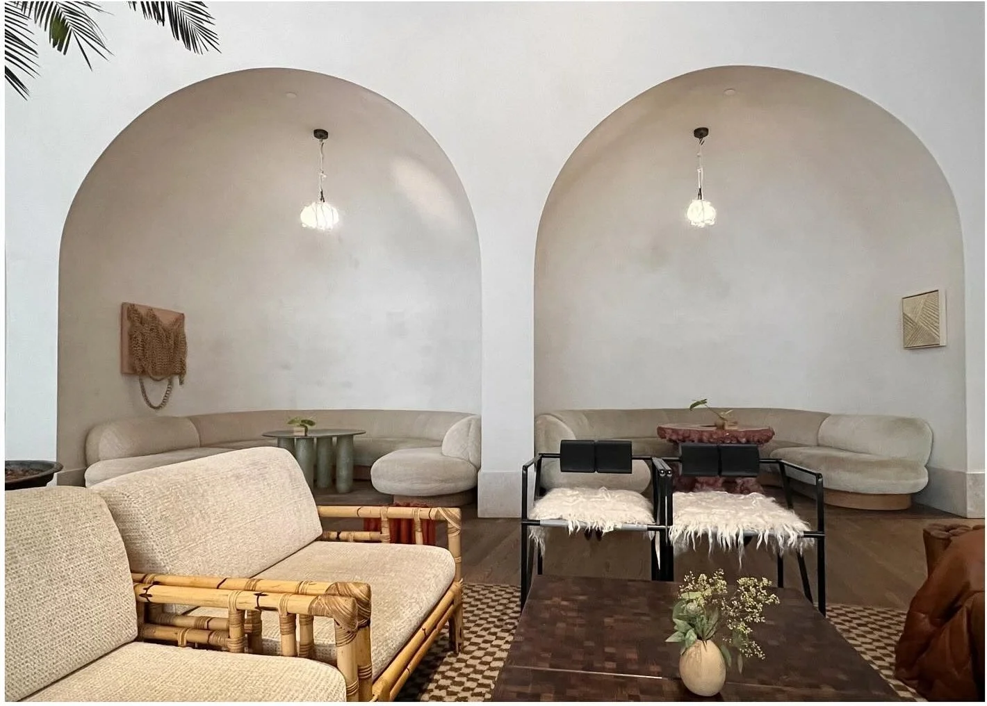 Lounge seating arranged beneath large pale plaster arches
