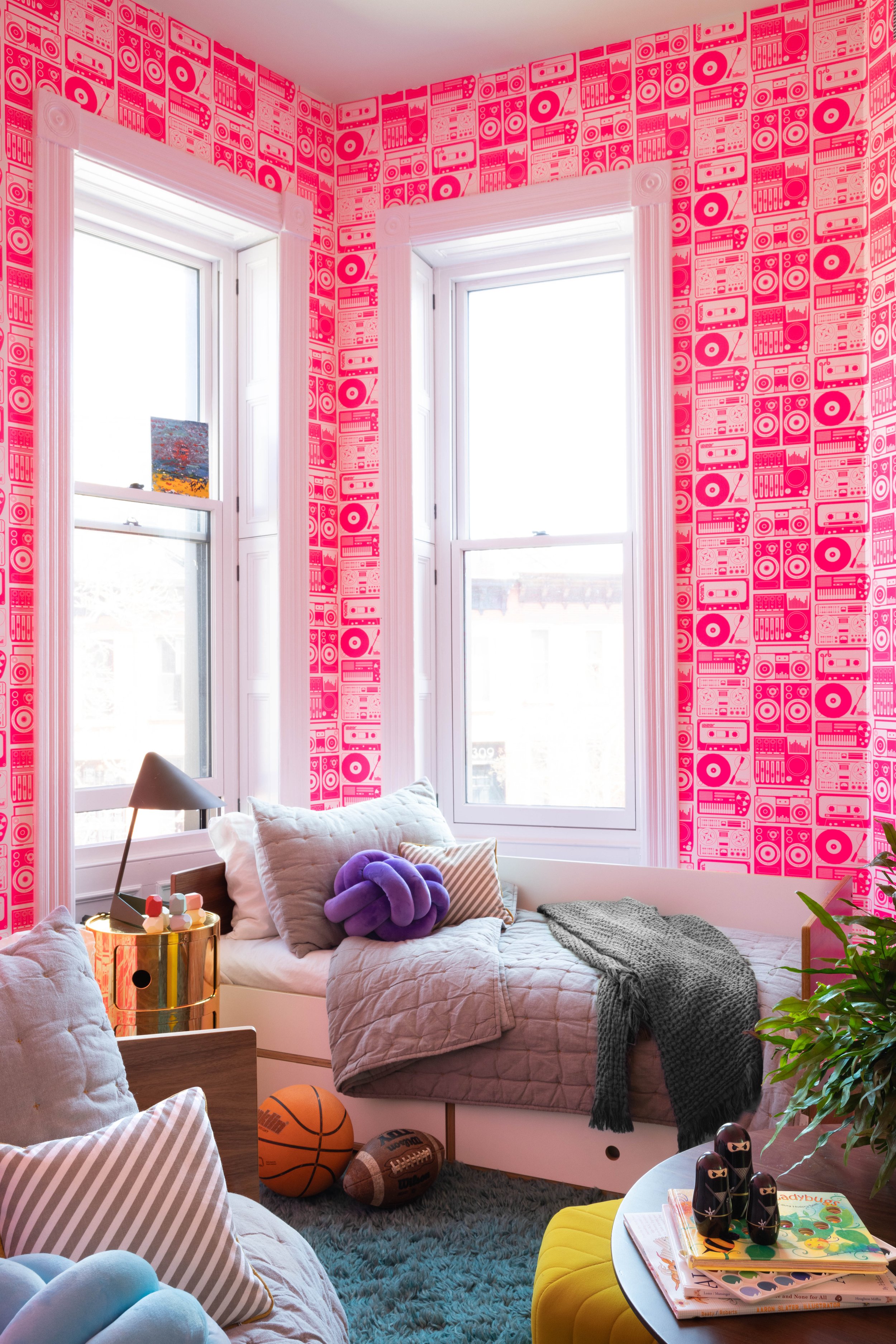 Bedroom with vivid red wallpaper and upholstered seating.