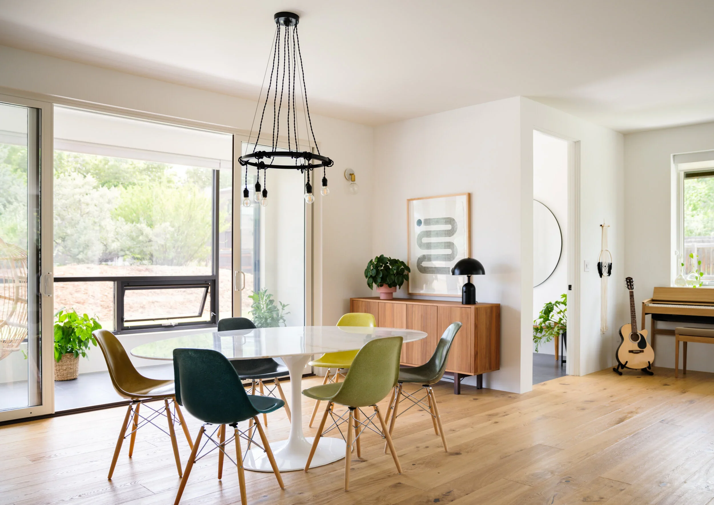  Learning To Fly ↗  A collected dining room with colorful chairs and black lighting.