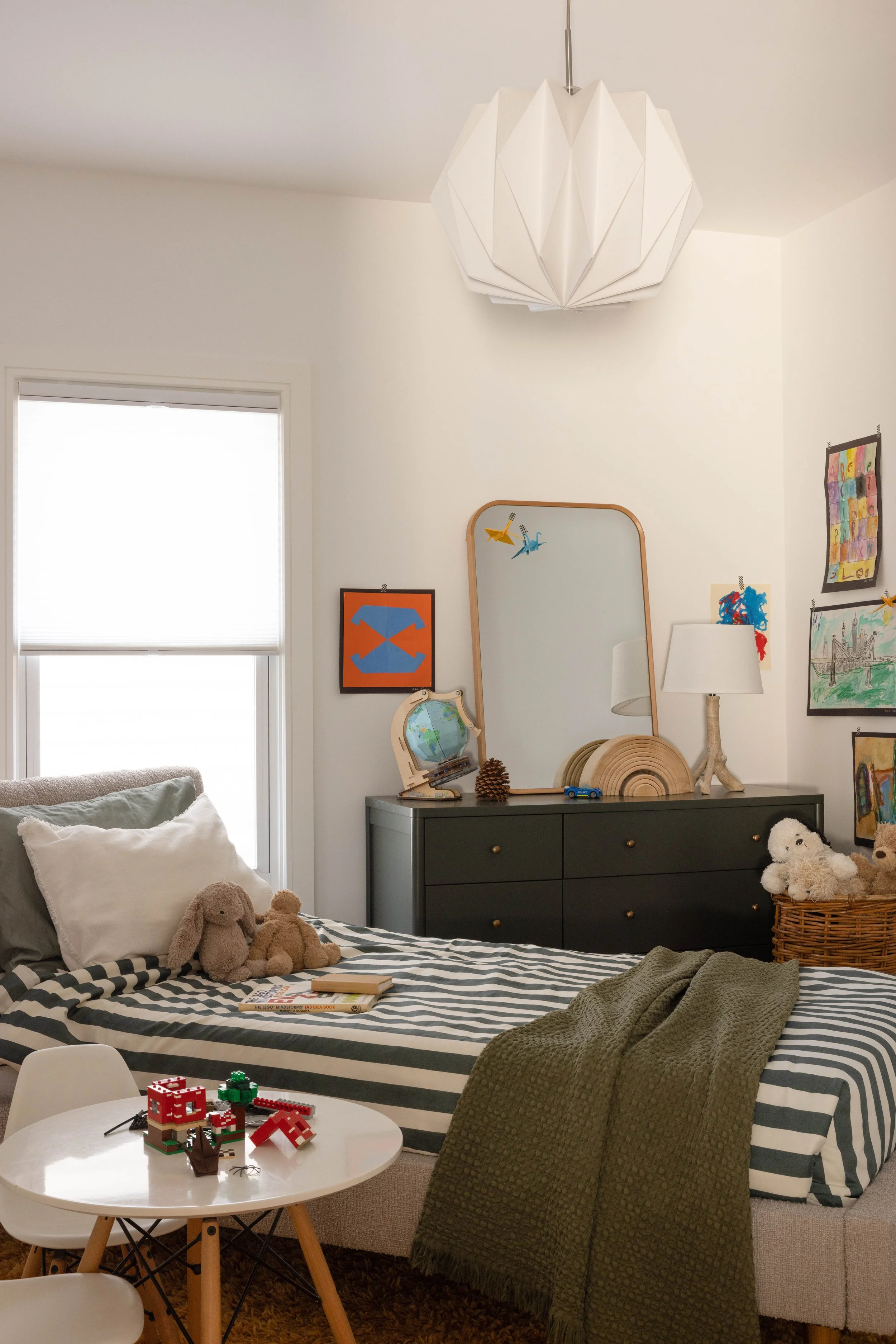 Bedroom with layered neutral bedding and framed art.