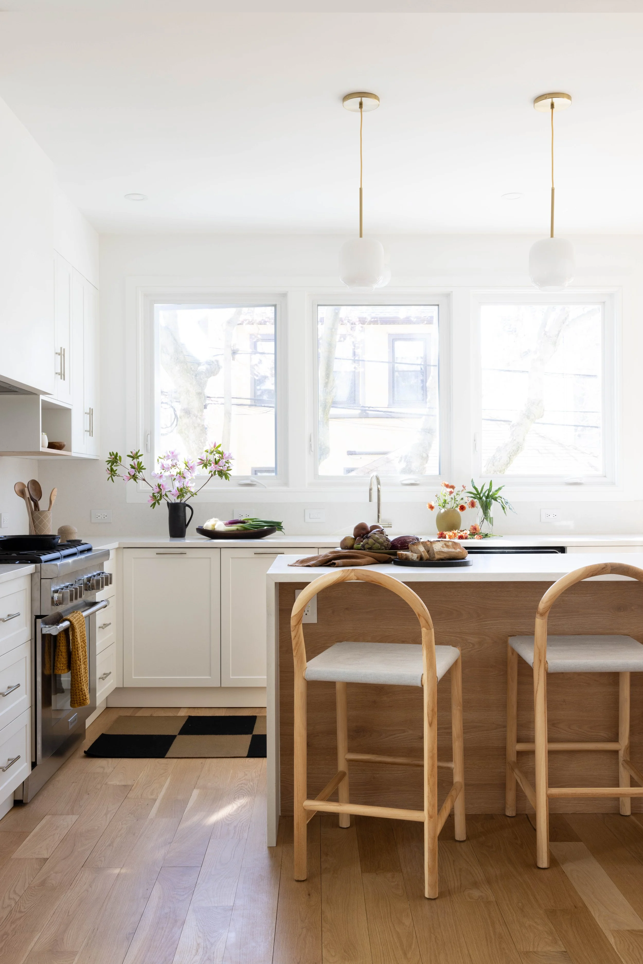 Dining nook with a round table and woven chairs beside the kitchen.