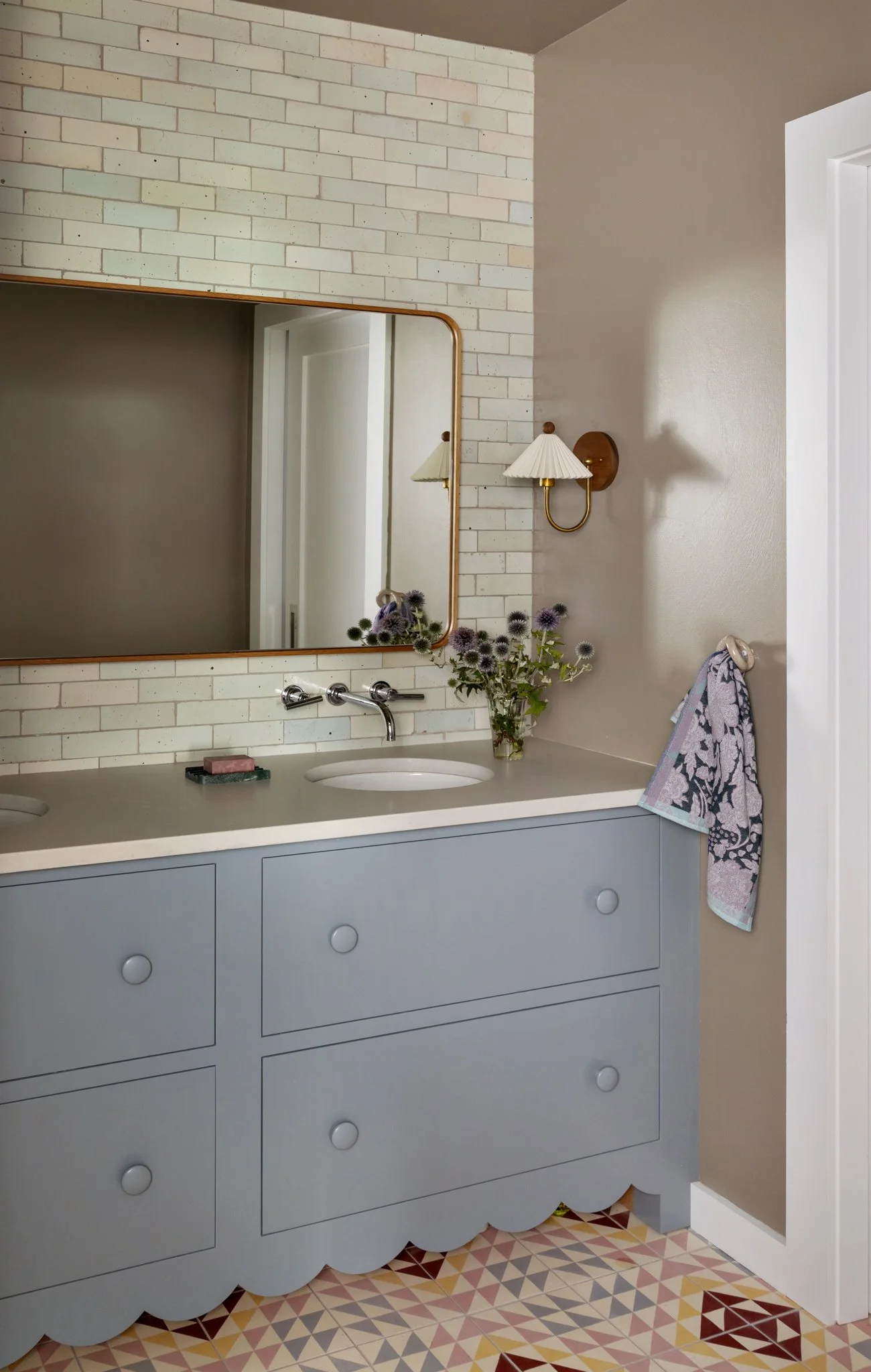 Pale blue bathroom vanity with a broad mirror and white counter.