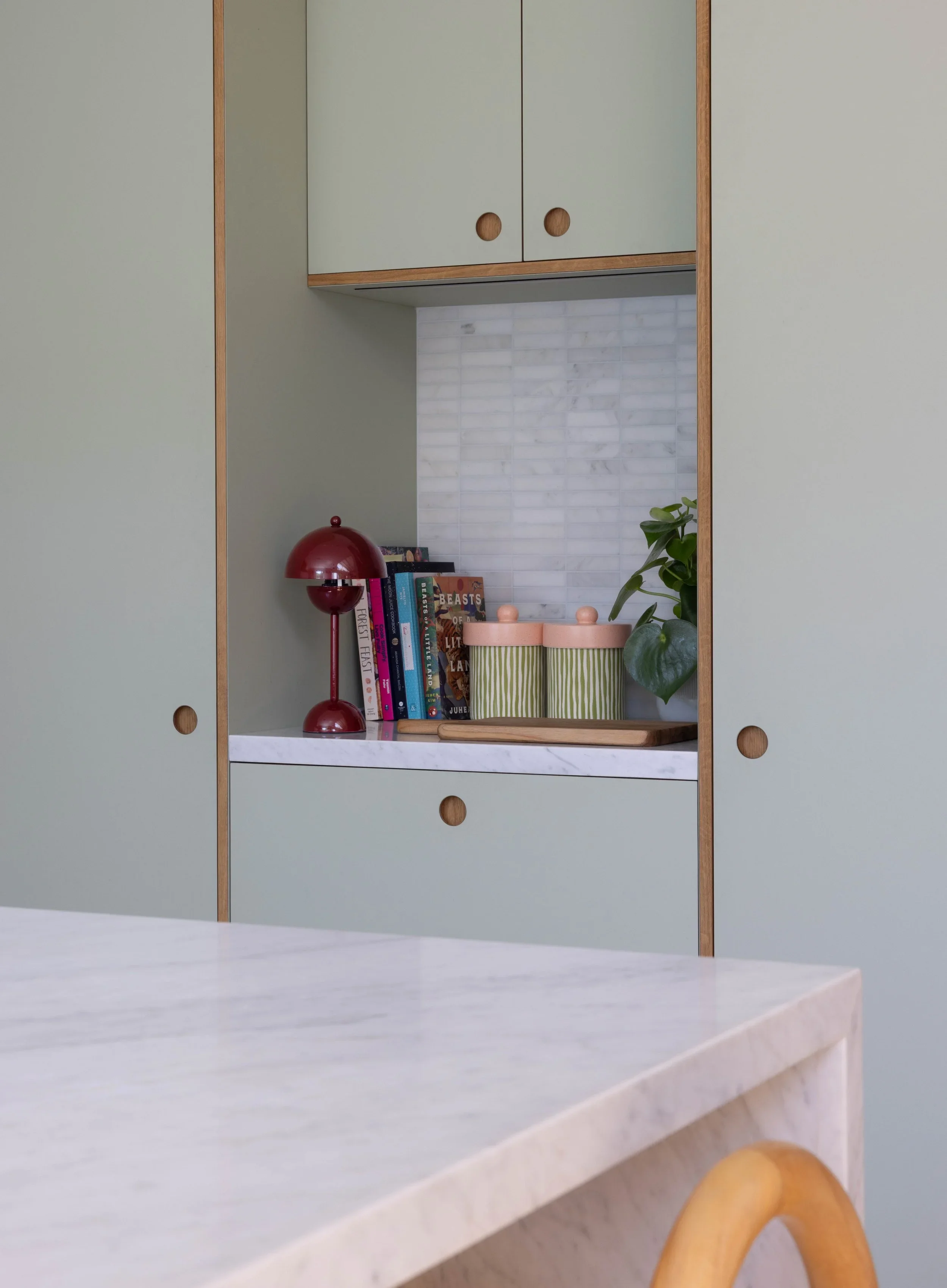 Mint cabinet door above a marble kitchen counter.