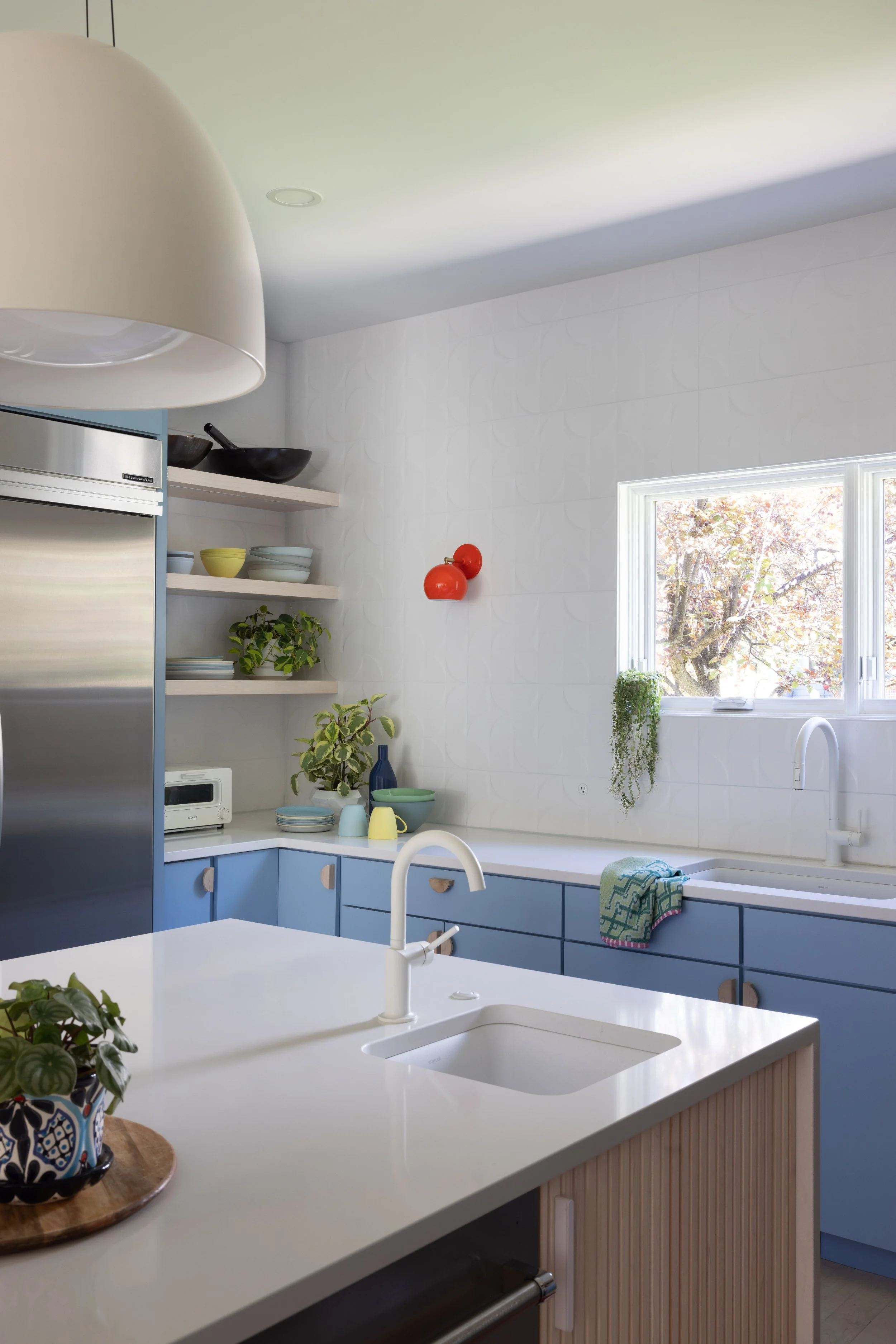 Kitchen island with wood counters and pale blue cabinetry.