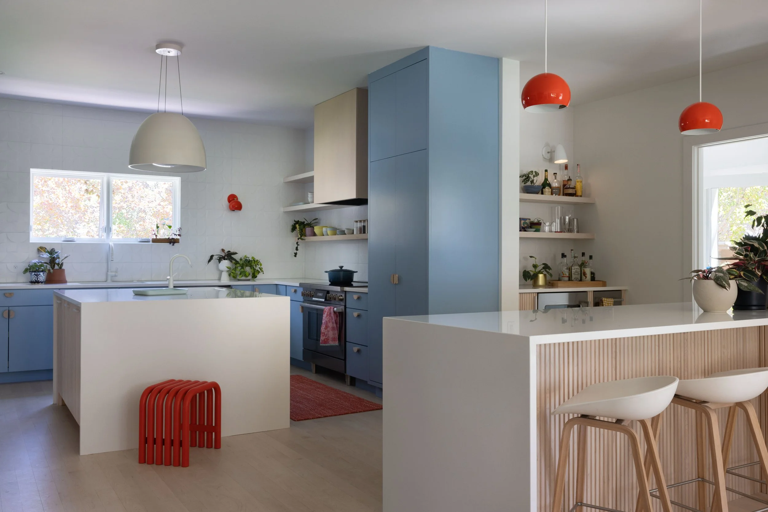 Kitchen with blue cabinetry and red pendant lighting.